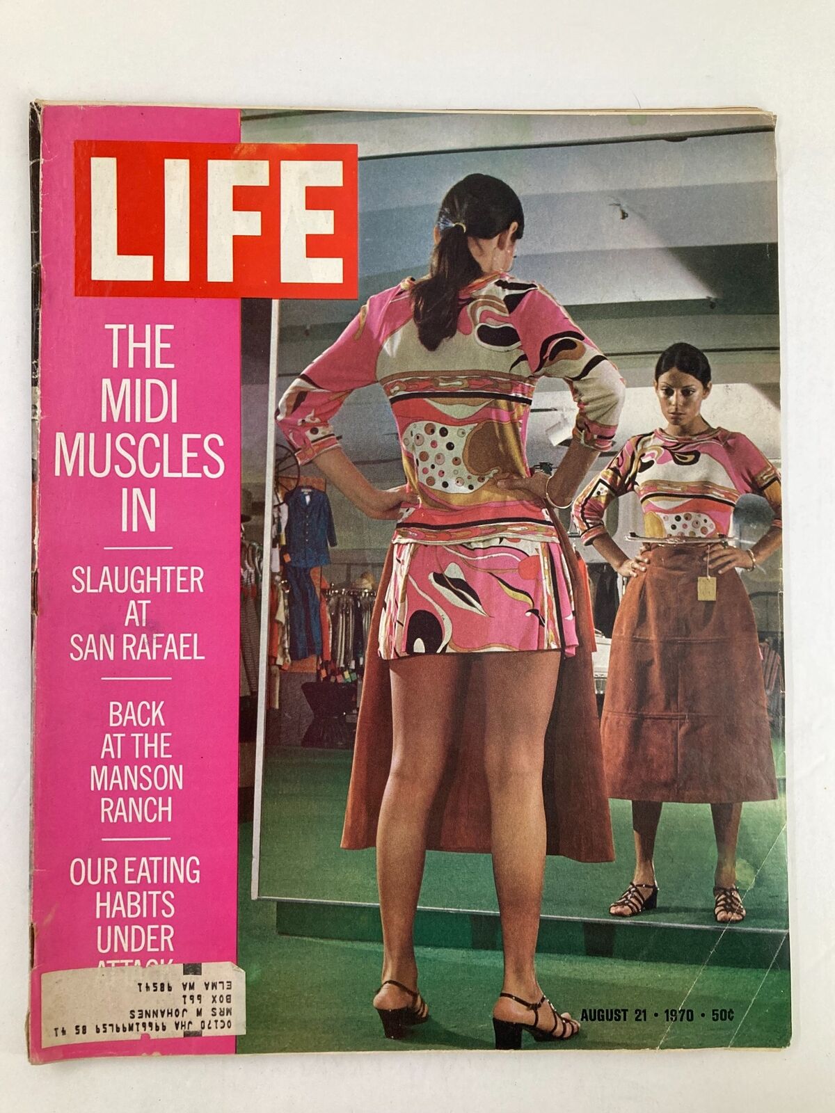 Cover of VTG Life Magazine August 21 1970 featuring the article 'The Midi Muscles In' showcasing vibrant fashion of the 70s, with a woman trying on stylish outfits in a store mirror.