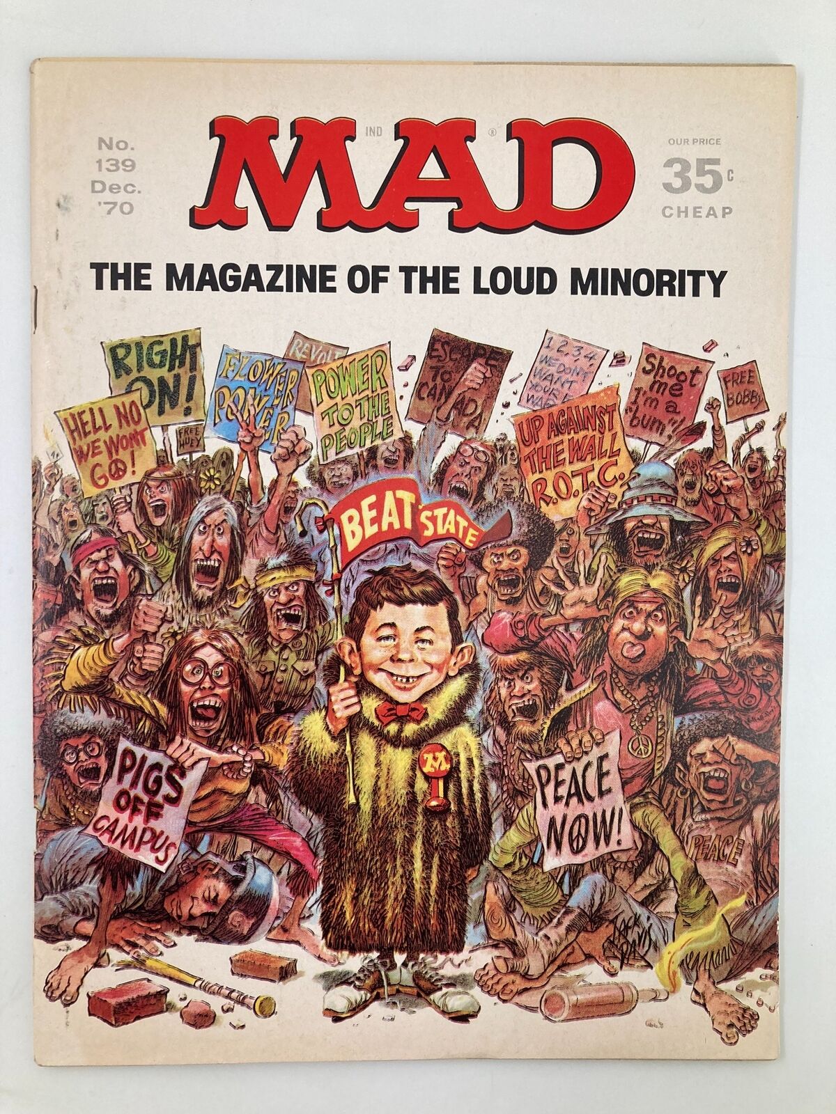 Cover of Mad Magazine December 1970 No. 139 Revolutionary Movement featuring a caricature of a boy giving a thumbs up amidst a crowd of protesters holding signs with slogans like 'Power to the People' and 'Peace Now'. This vintage magazine captures the satirical essence of the cultural revolution era.