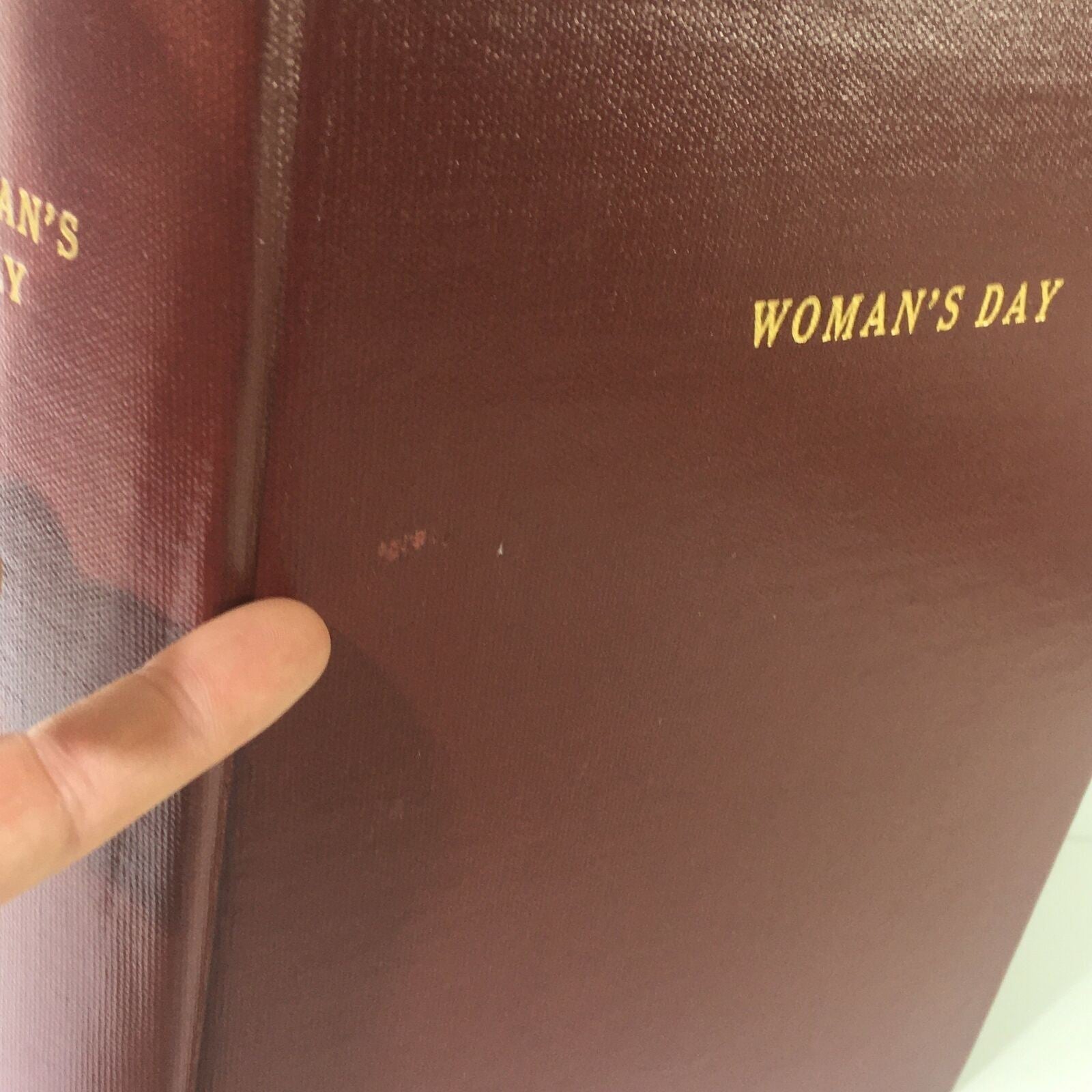 Close-up view of the spine of the 1970 Woman's Day Magazine showing minor wear and the title embossed.