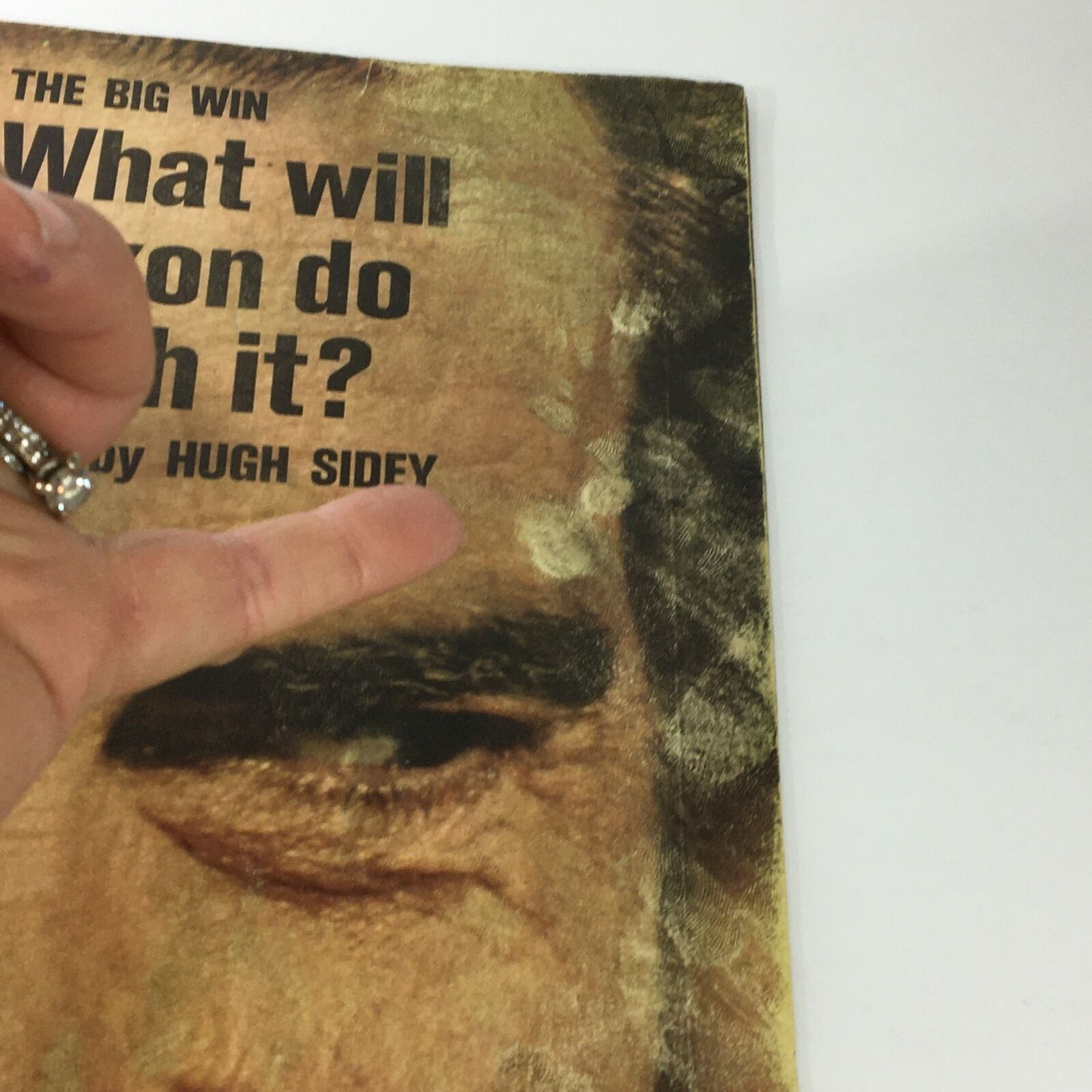 Detailed view of the cover of the November 1972 Life Magazine featuring Richard Nixon, highlighting the title 'The Big Win' and the article by Hugh Sidey, with a finger pointing at Nixon's eye.