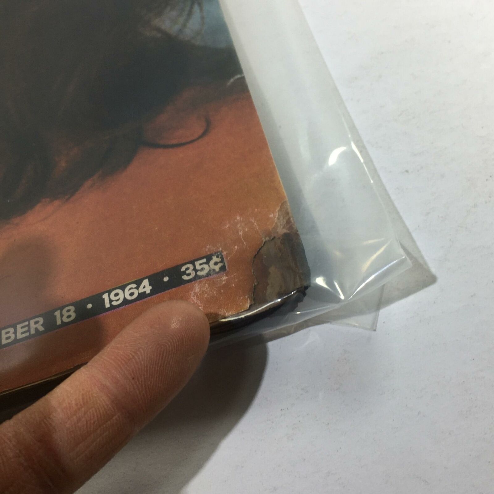 Close-up view of the corner damage on the December 18, 1964 VTG Life Magazine, featuring Elizabeth Taylor, highlighting the wear typical for a vintage publication.