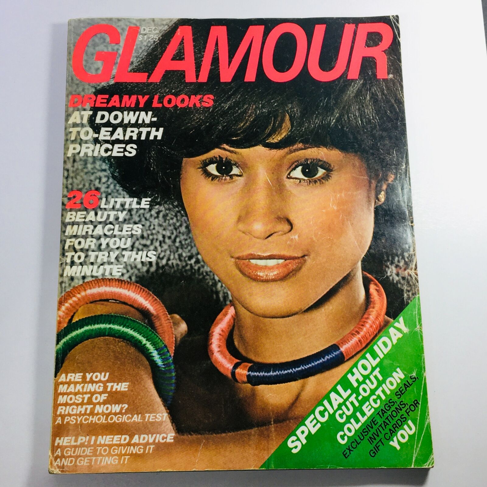 Glamour Magazine December 1976 featuring Beverly Johnson on the cover, highlighting dreamy looks and beauty tips, showcasing a vintage aesthetic with bold colors and graphic design.
