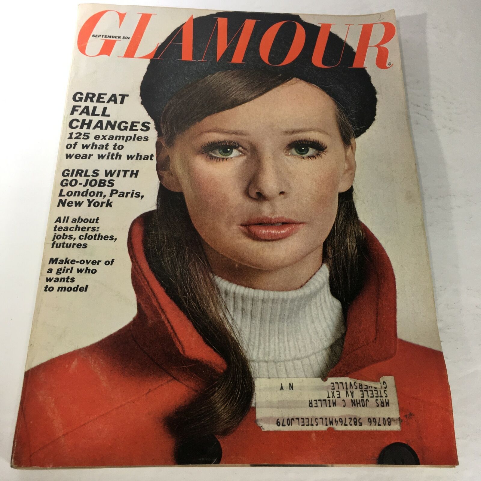 Vintage Glamour Magazine from September 1965 featuring the headline 'Make-Over Of A Girl Who Wants To Be Model'. The cover showcases a model with long hair, wearing a stylish red coat and a black hat, highlighting the fashion and beauty standards of the 1960s.