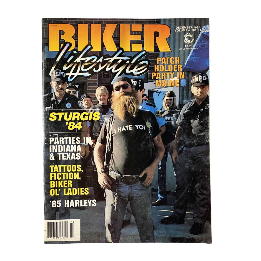 Cover of VTG Biker Lifestyle Magazine December 1984 featuring a patch holder party in Maine, showcasing a bearded man with a shirt reading 'I HATE YOU' and a group of bikers and police officers in the background.