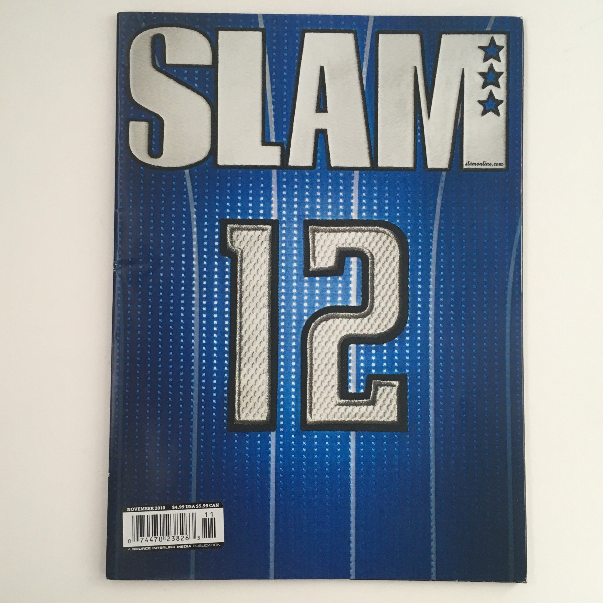 Cover of Slam Magazine November 2010 featuring the title 'SLAM 12' on a blue background, part of the Stephen Curry and Ricky Rubio edition.