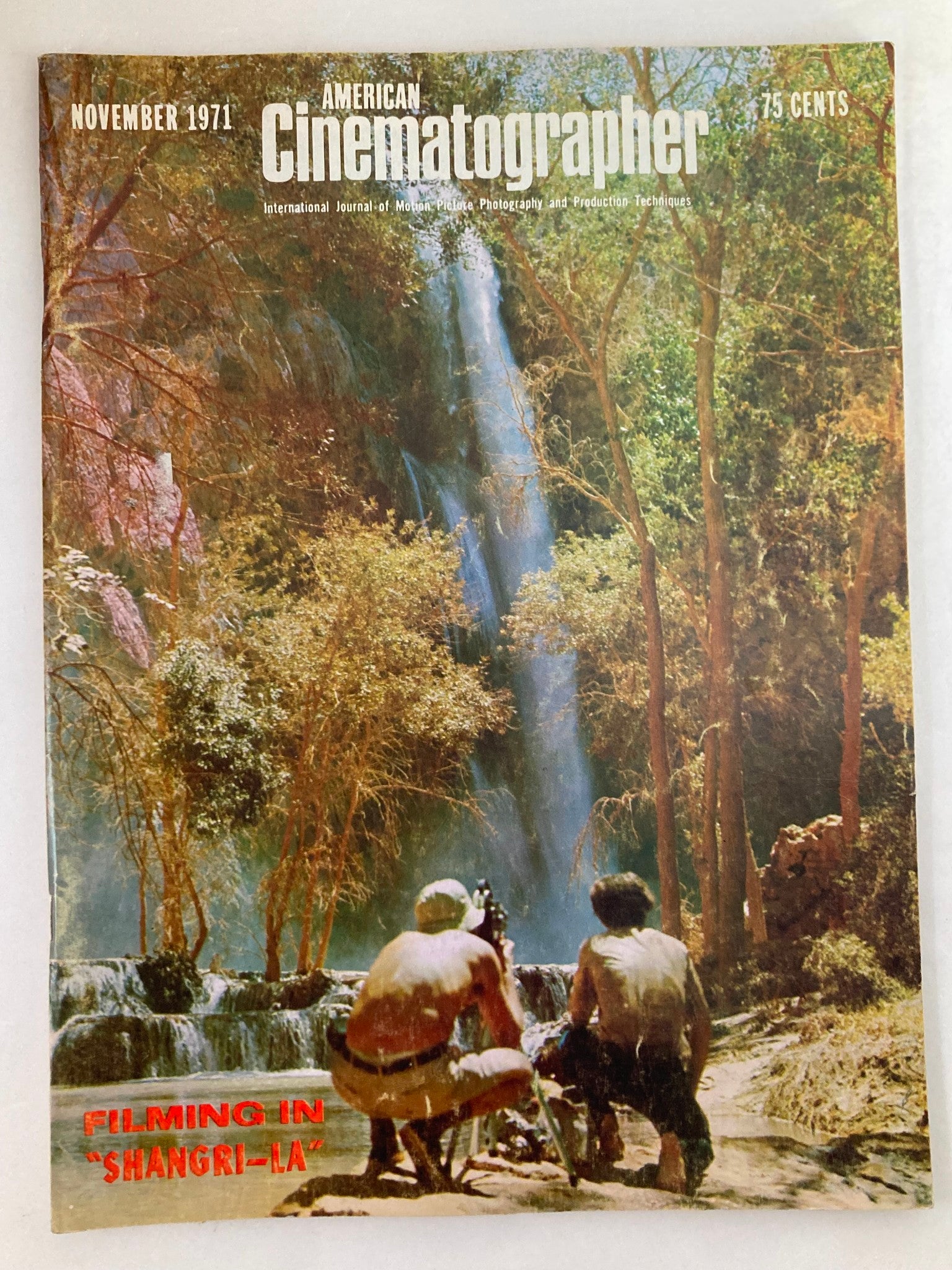 Cover of American Cinematographer Magazine November 1971 featuring the title 'Filming in Shangri-La' with a scenic waterfall and two film crew members in the foreground.