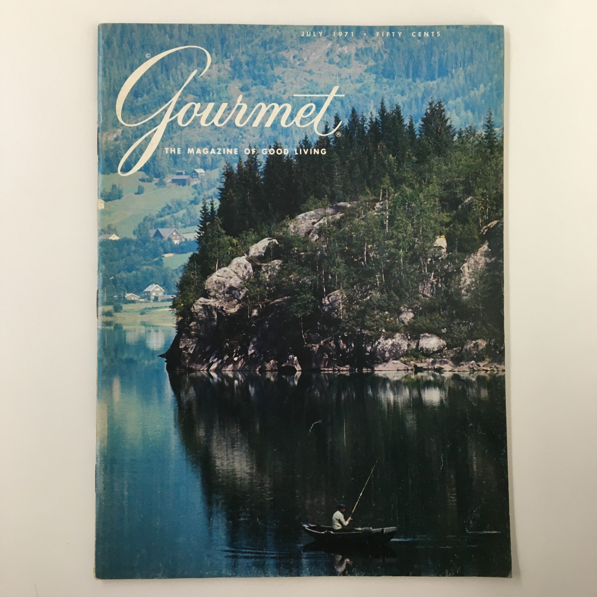 Cover of VTG Gourmet Magazine July 1971 featuring a scenic landscape of mountains and forests reflected in a calm lake, showcasing the theme 'Mountains, Forests and Fiords'.
