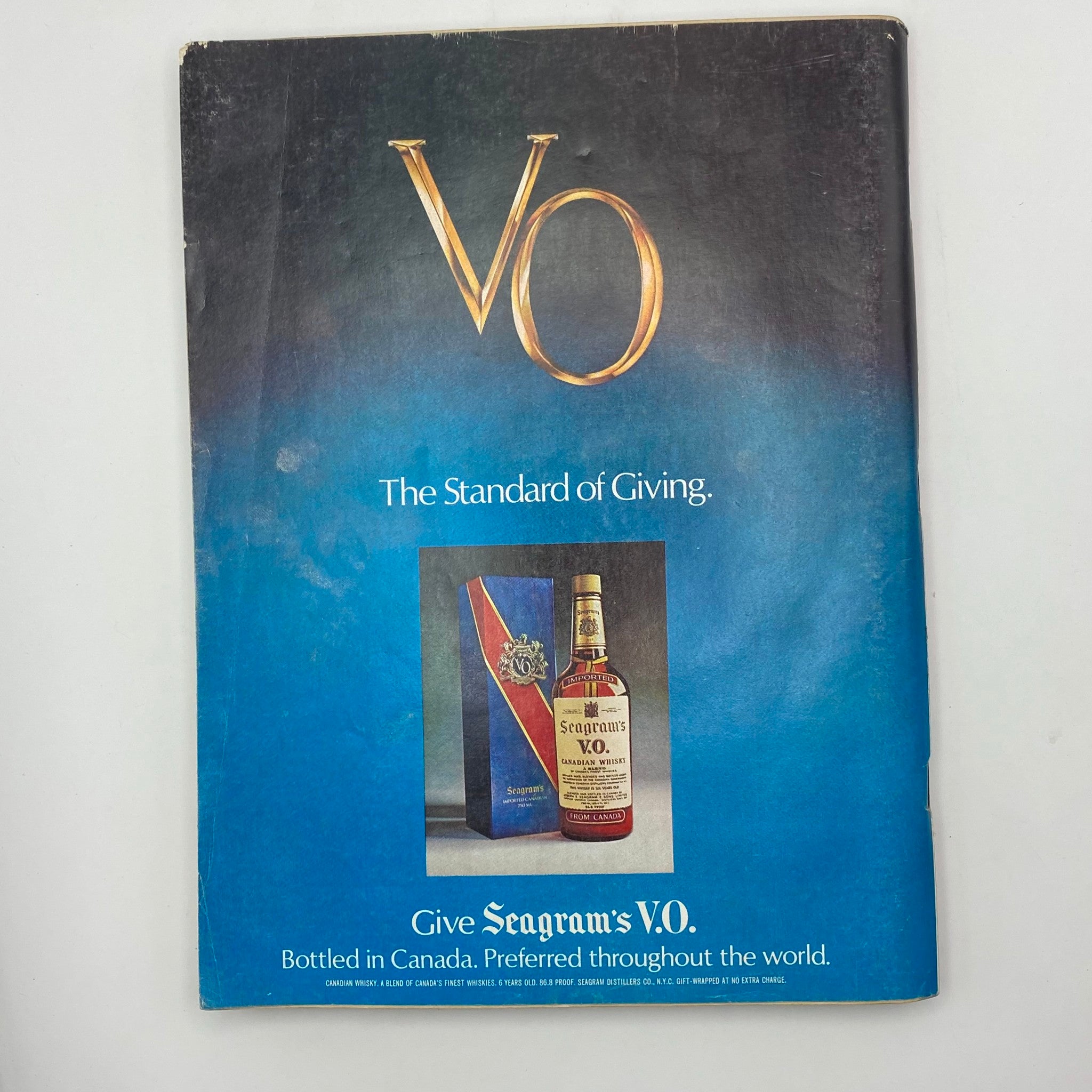 Playboy Magazine December 1977 cover showcasing a vintage ad for Seagram's V.O. whiskey, featuring the tagline 'The Standard of Giving' and an image of the whiskey bottle and gift box.