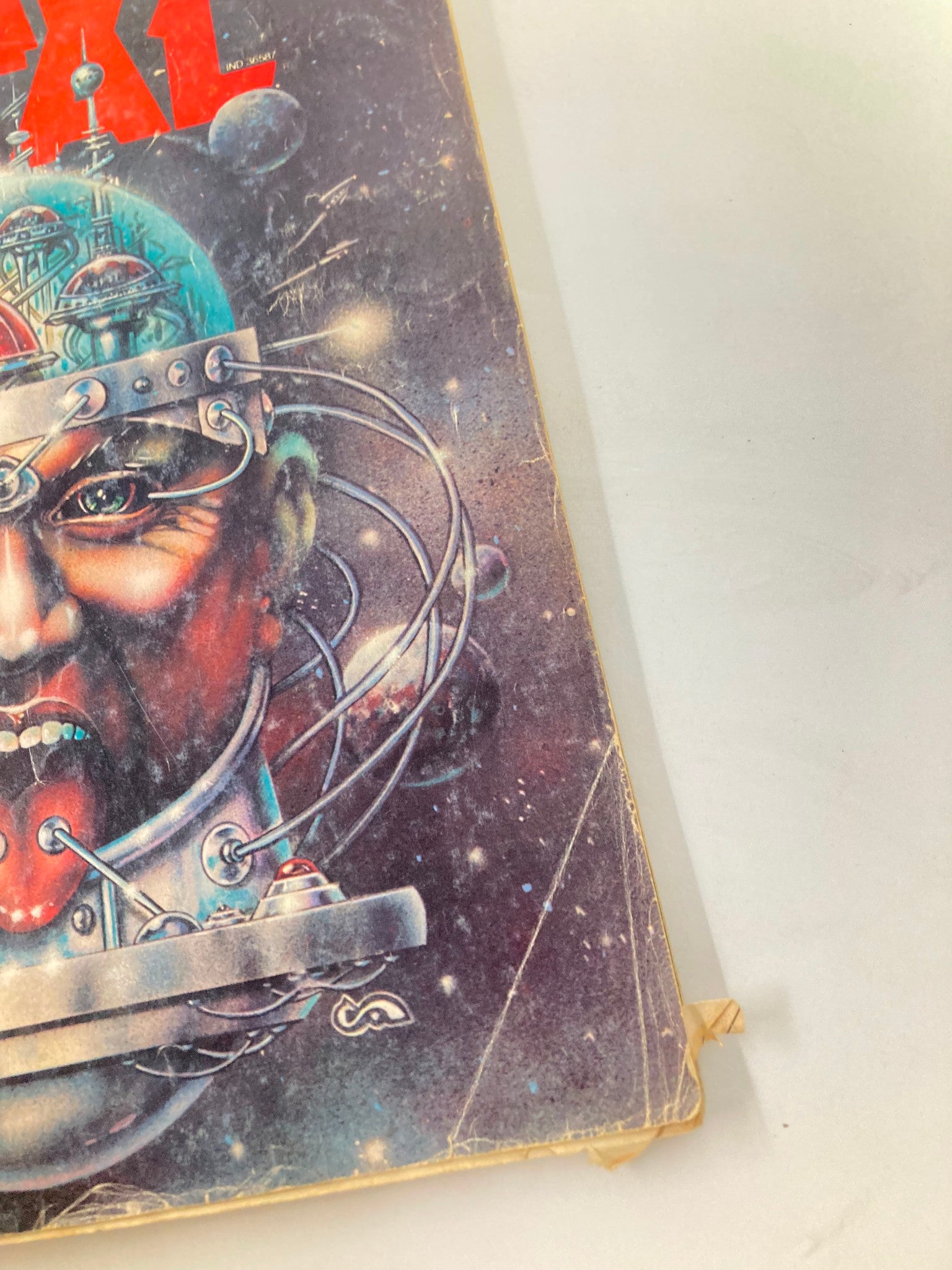 Close-up view of the cover of VTG Heavy Metal Magazine April 1979, showcasing detailed artwork of a futuristic character with a helmet and various mechanical elements, highlighting the magazine's unique blend of fantasy and science fiction.