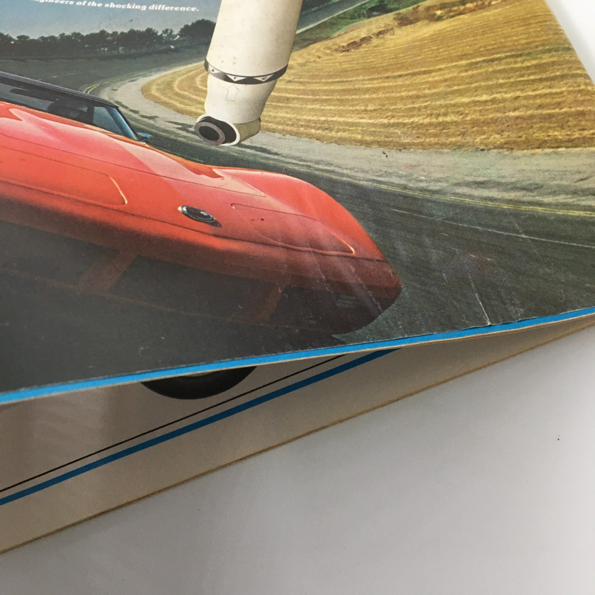 Close-up of the edge of VTG Car and Driver Magazine January 1975 showing wear and a bright red sports car on the cover, highlighting its vintage charm.