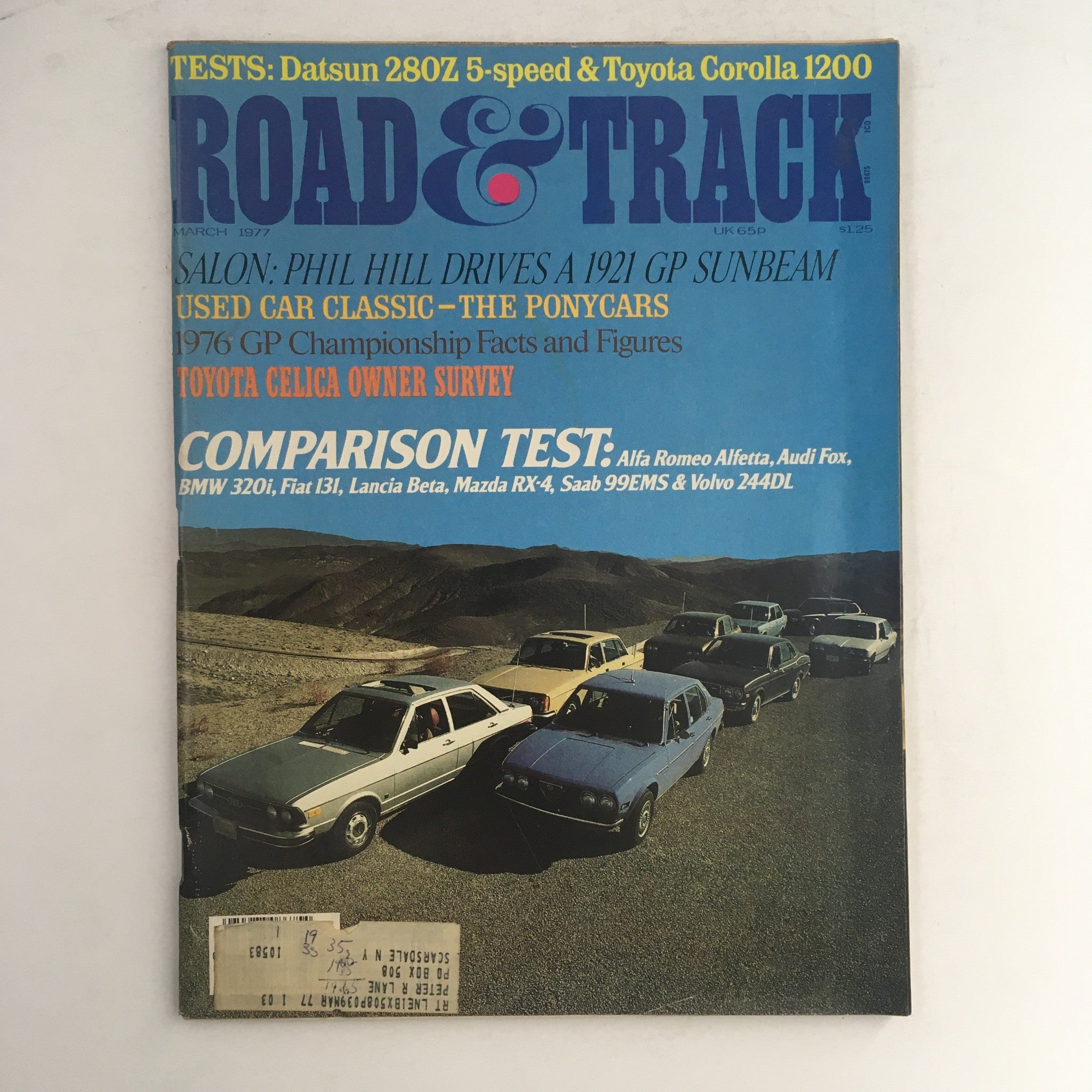 Cover of Road & Track Magazine March 1977 featuring a comparison test of Alfa Romeo Alfetta, Audi Fox, and Mazda RX-4 with a background of several parked cars.