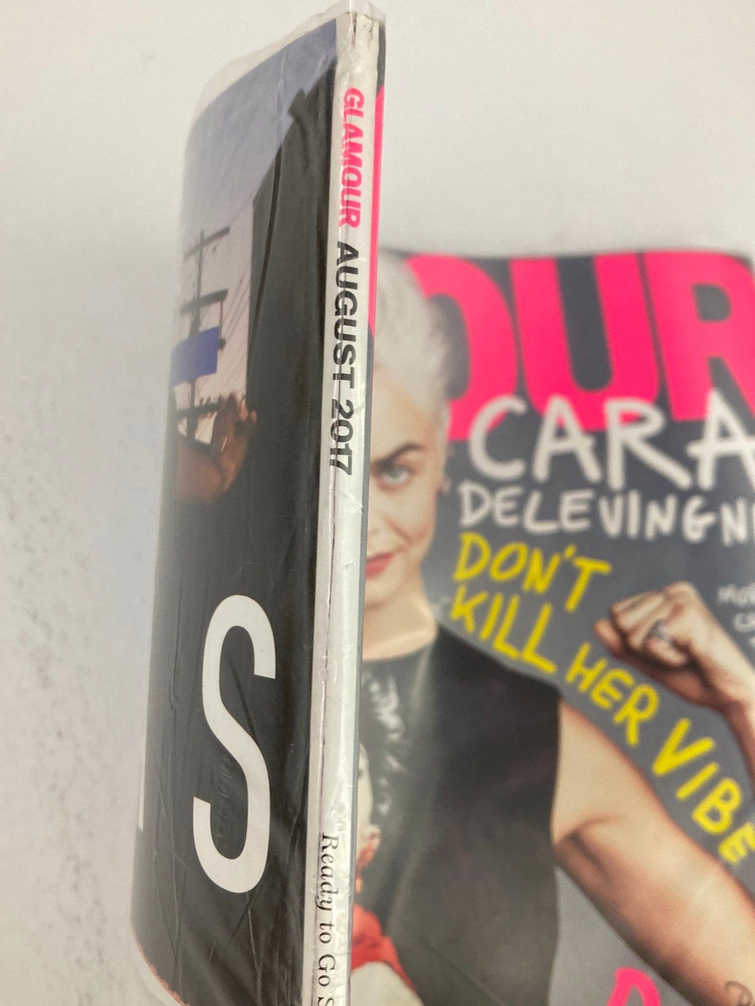 Spine view of Glamour Magazine August 2017 featuring Cara Delevingne with the text 'Glamour August 2017' printed, showcasing its sealed condition and vintage appeal.