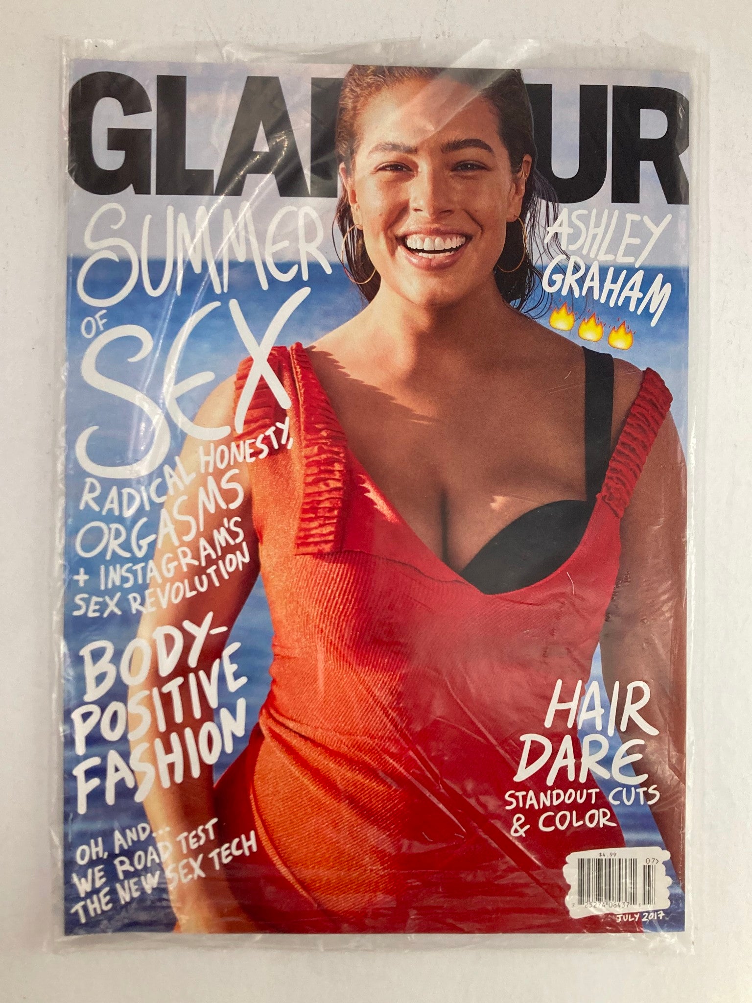 Glamour Magazine July 2017 featuring Ashley Graham on the cover, promoting body-positive fashion. The magazine is sealed and showcases a bright, vibrant image of Graham smiling, with headlines about summer, sex, and body positivity.