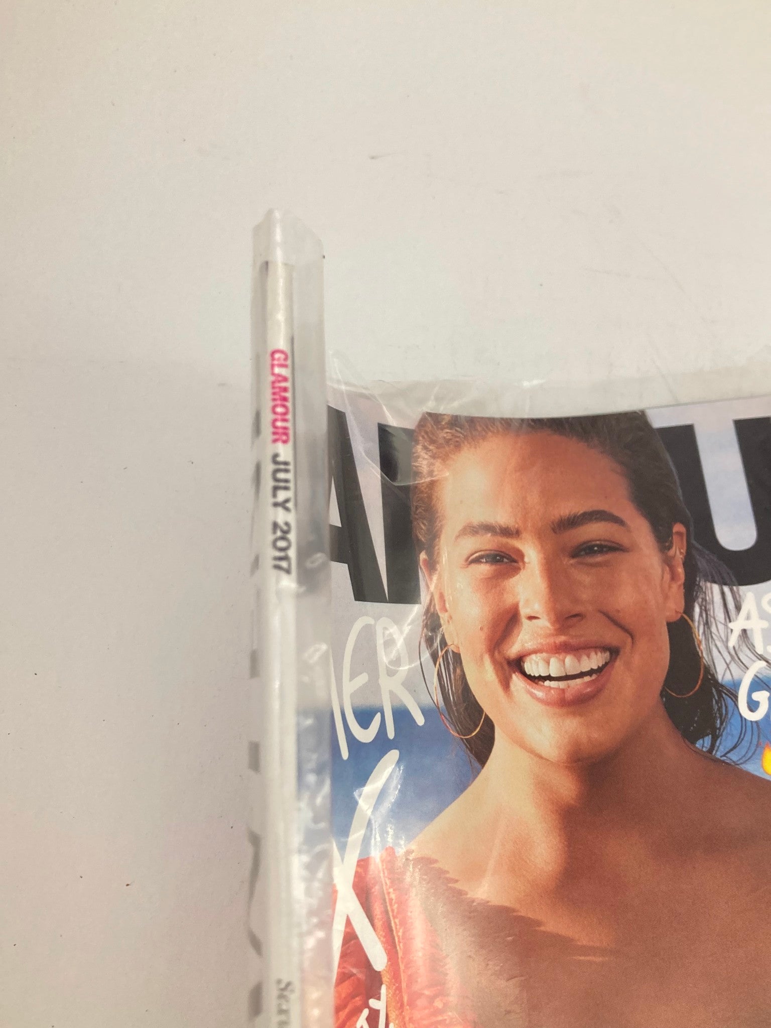 Side view of Glamour Magazine July 2017, highlighting the title and seal, with Ashley Graham's portrait visible on the cover. This collectible issue focuses on body-positive fashion and inclusivity.