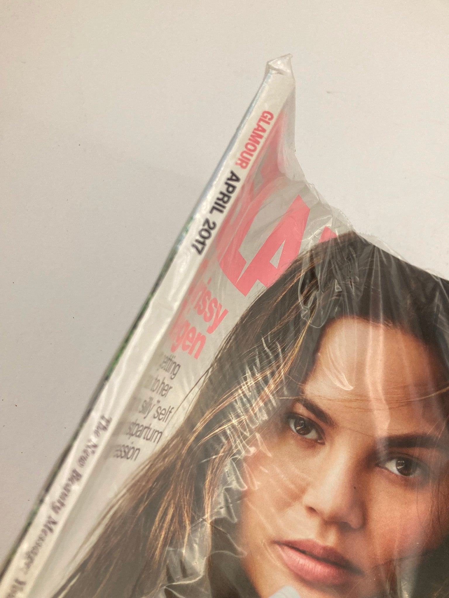 Close-up view of the sealed Glamour Magazine April 2017 featuring Chrissy Teigen, showcasing details from the cover and highlighting the issue's focus on mental health.
