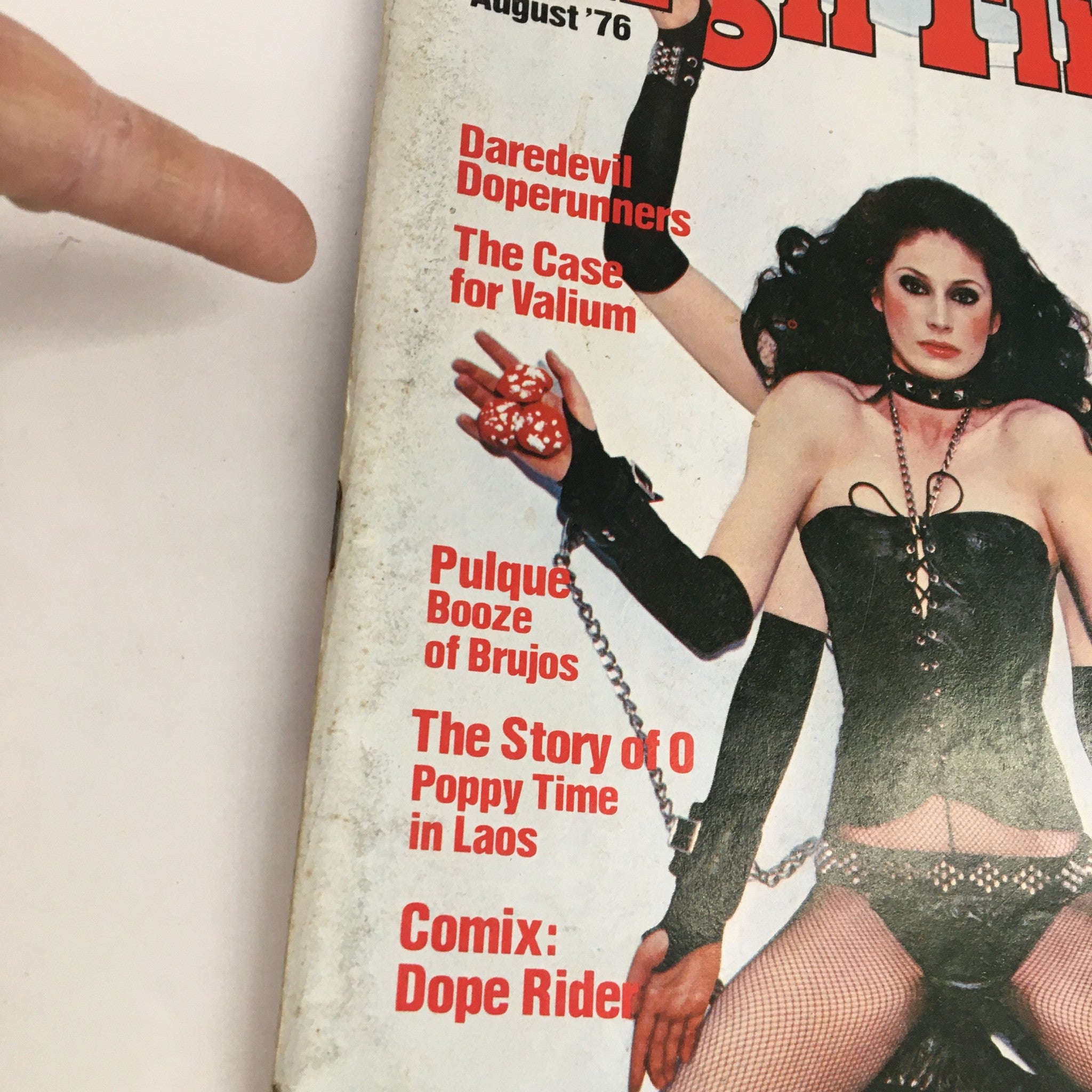 Close-up of High Times Magazine August 1976 cover highlighting article titles such as 'Daredevil Doperunners' and 'The Case for Valium', alongside an image of the model in a striking outfit, emphasizing the magazine’s unique aesthetic.