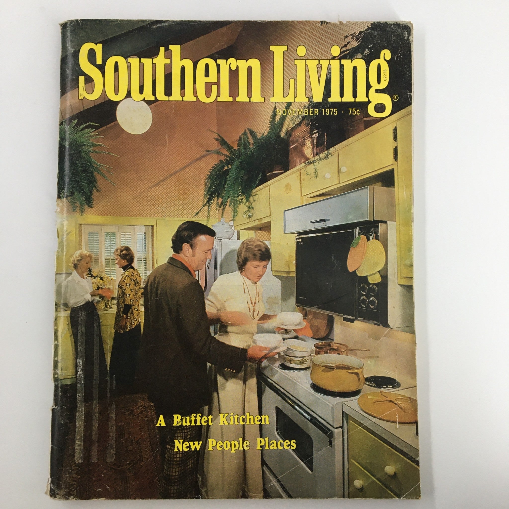 Cover of the Southern Living Magazine from November 1975 featuring a vintage kitchen scene with a buffet setting and people enjoying cooking. Title: 'A Buffet Kitchen, New People Places'.