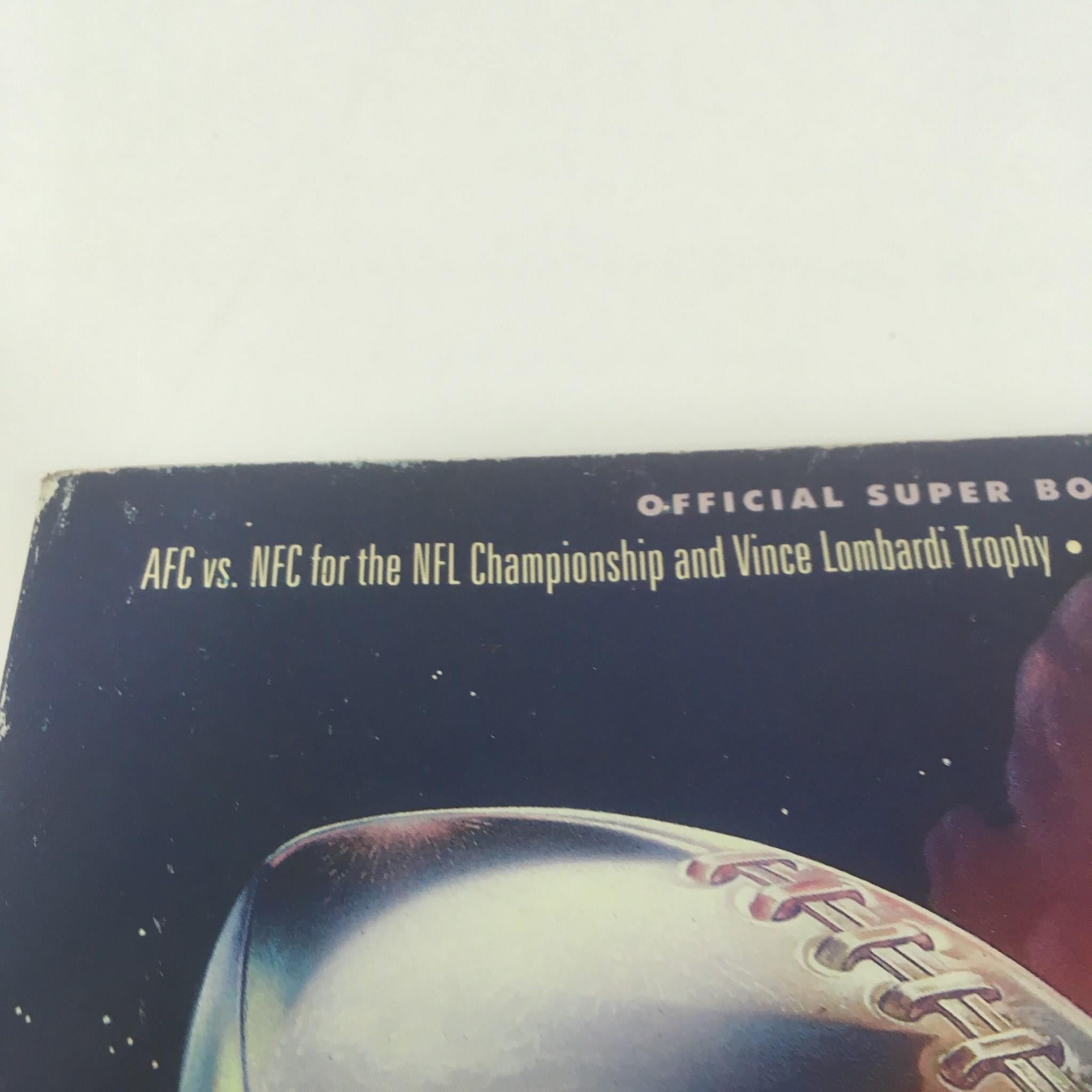 Close-up of the Super Bowl XXVI Game Program from January 26, 1992, showing the text 'AFC vs. NFC for the NFL Championship and Vince Lombardi Trophy'.