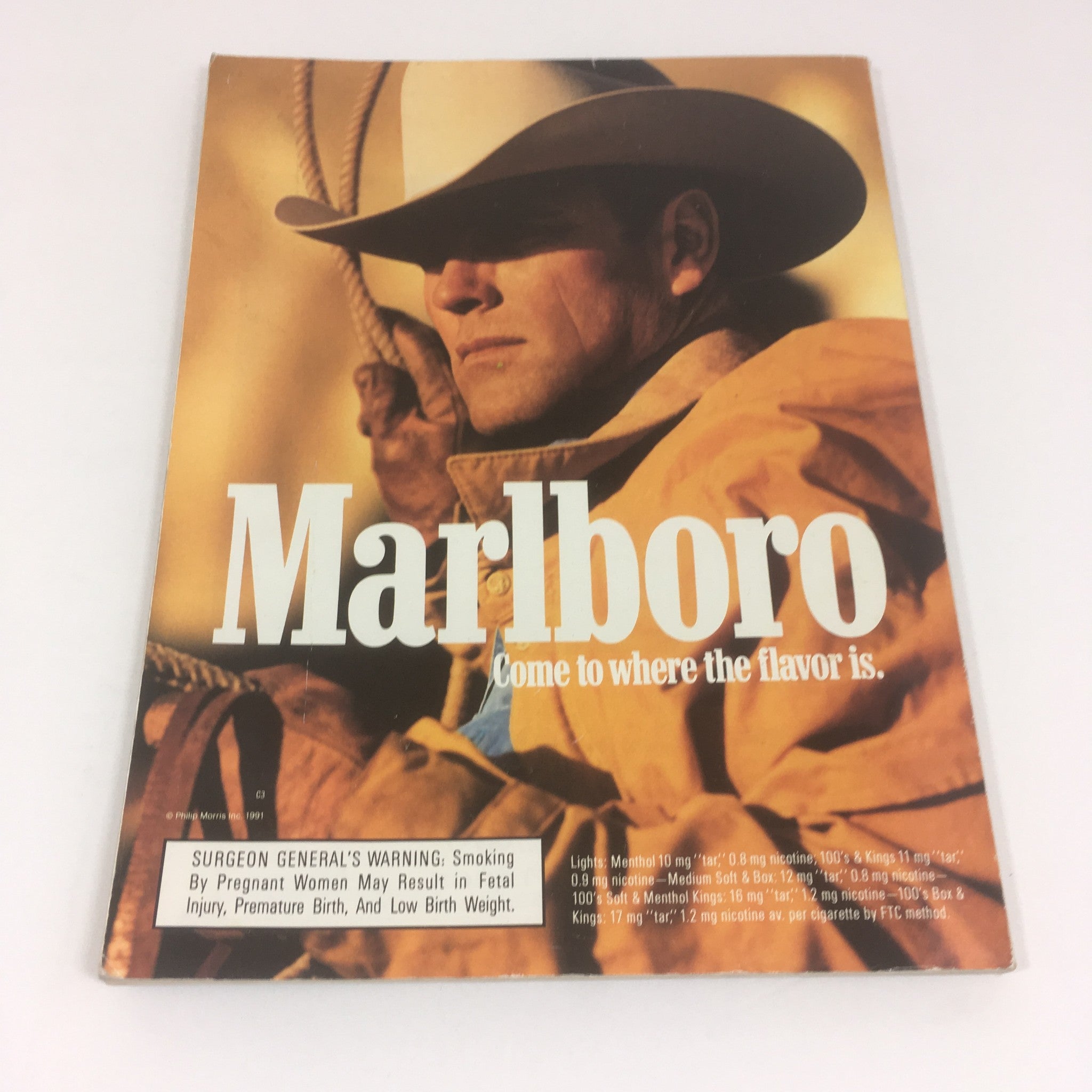 Cover of the Super Bowl XXVI Game Program from January 26, 1992, featuring a cowboy in a hat, representing the Marlboro cigarette brand with the slogan 'Come to where the flavor is.'