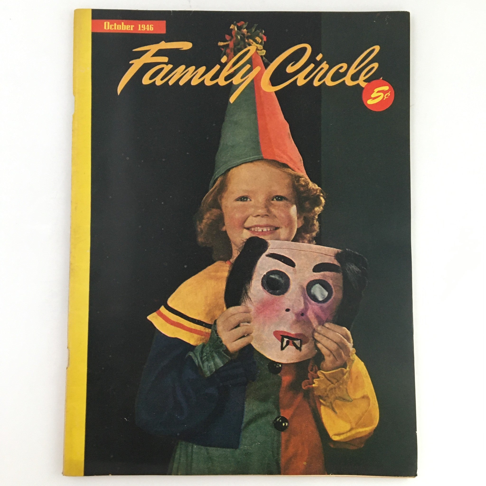 The Family Circle Magazine October 1946 cover featuring a smiling girl in a colorful clown costume holding a mask, a whimsical representation of mid-20th century childhood.