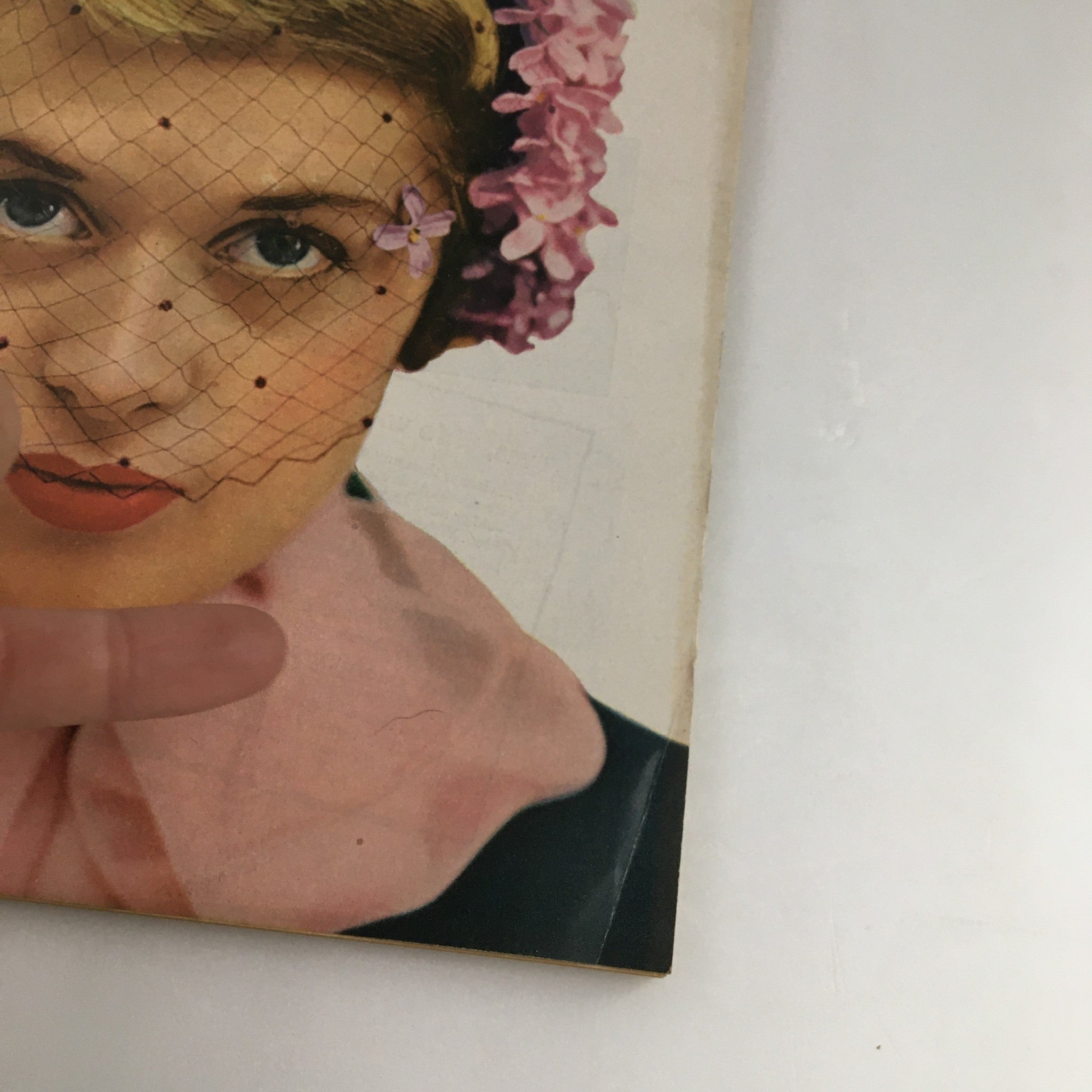 Close-up of The Family Circle Magazine April 1951 cover with a focus on the woman's face adorned with a floral headpiece and veil, emphasizing vintage details.