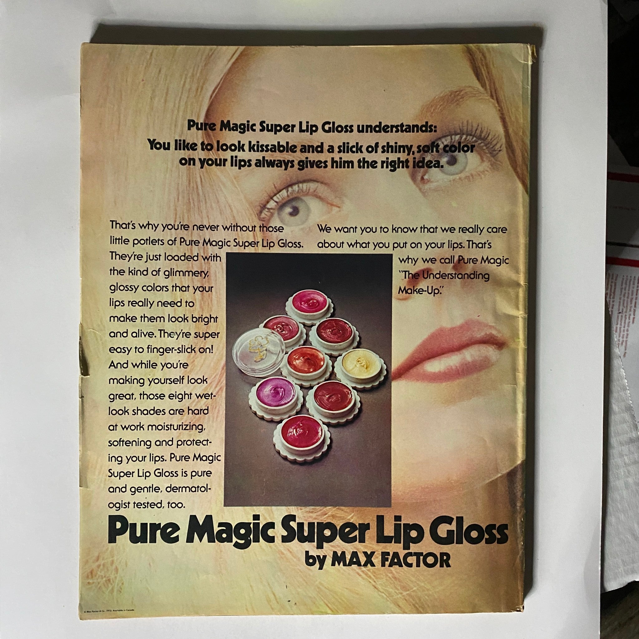 Cover of the VTG Seventeen Magazine April 1973 featuring 'My Two Years in Uganda.' The image displays an advertisement for Max Factor's Pure Magic Super Lip Gloss, highlighting colorful lip gloss pots, with text promoting the product's benefits and relevance to 1970s beauty trends.