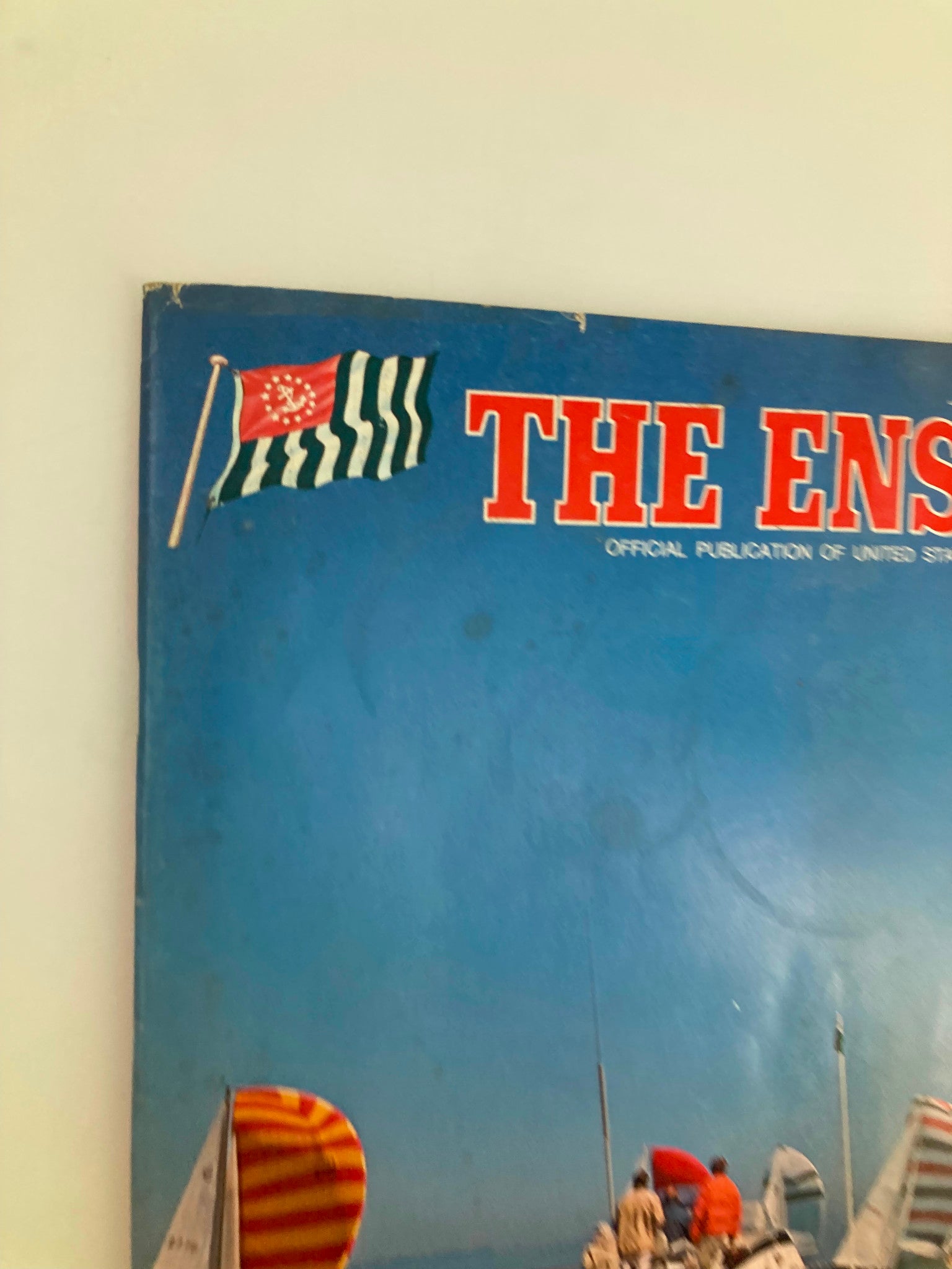 Cover detail of VTG The Ensign Magazine January 1975 featuring the Singapore flag and a vibrant sailing scene, highlighting the magazine's nautical theme.