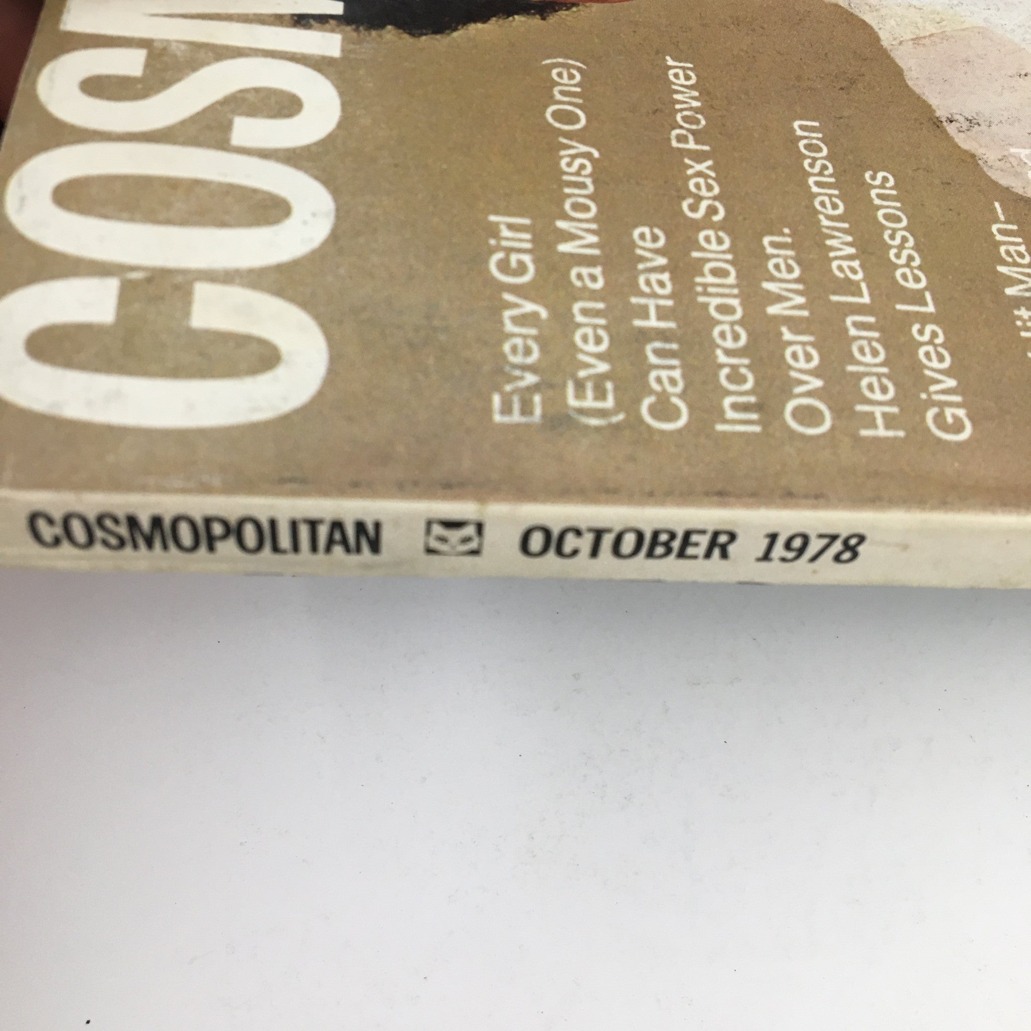 Close-up view of the spine of Cosmopolitan Magazine October 1978 showcasing the title and key articles. The magazine features the bold and iconic cover design by Peggy Dillard along with mentions of articles such as 'Every Girl Can Have Incredible Sex Power' and insights from David Brenner.