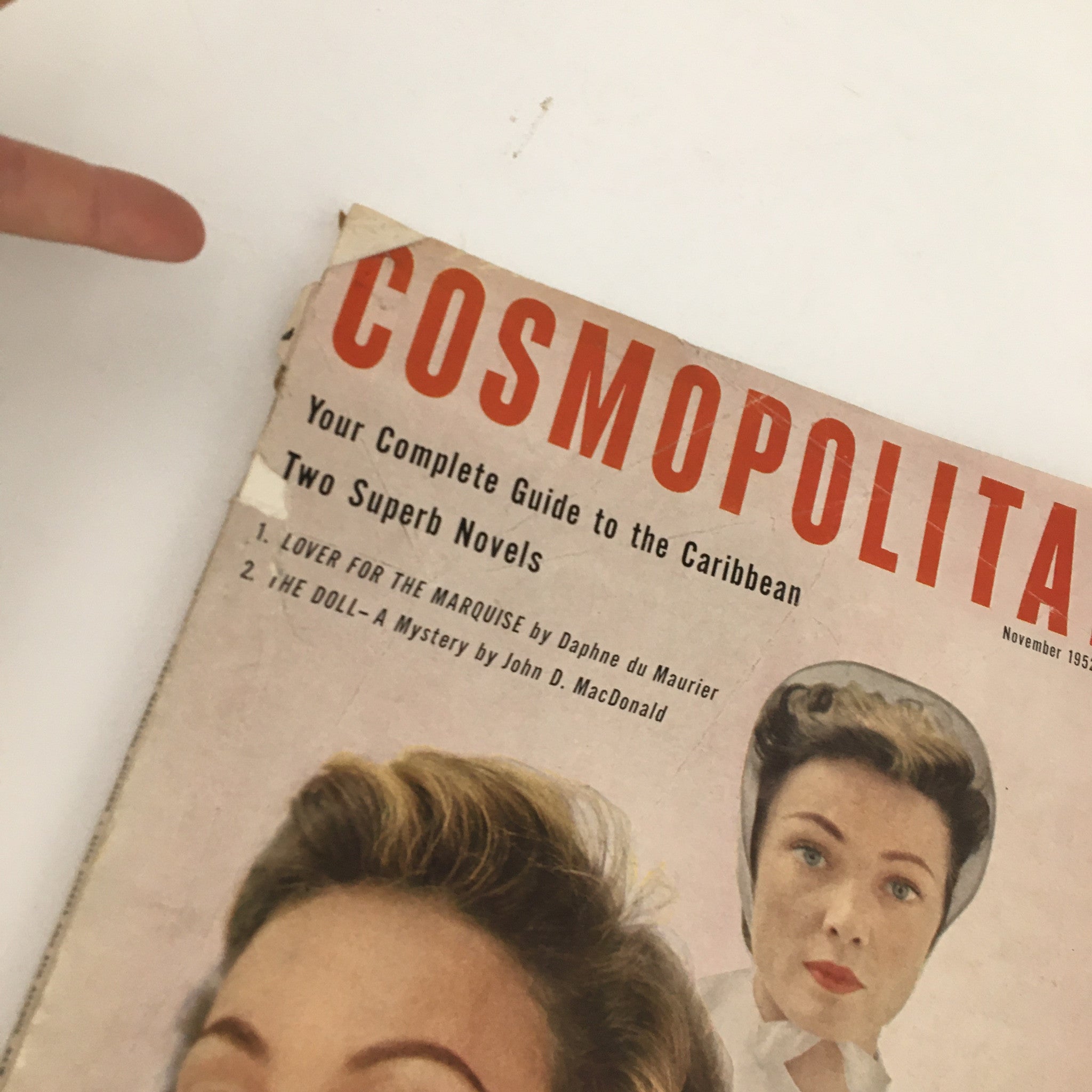 Close-up of Cosmopolitan Magazine November 1952 cover showing the title and featured novels 'Lover for the Marquise' and 'The Doll'.