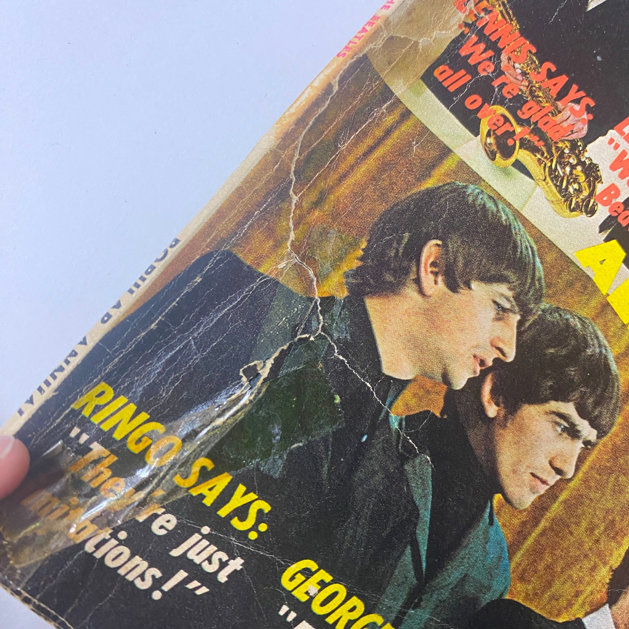 Close-up of the cover of Popular Annual Magazine September 1964, featuring images of Ringo Starr and George Harrison from The Beatles, with damaged edges emphasizing its vintage condition.
