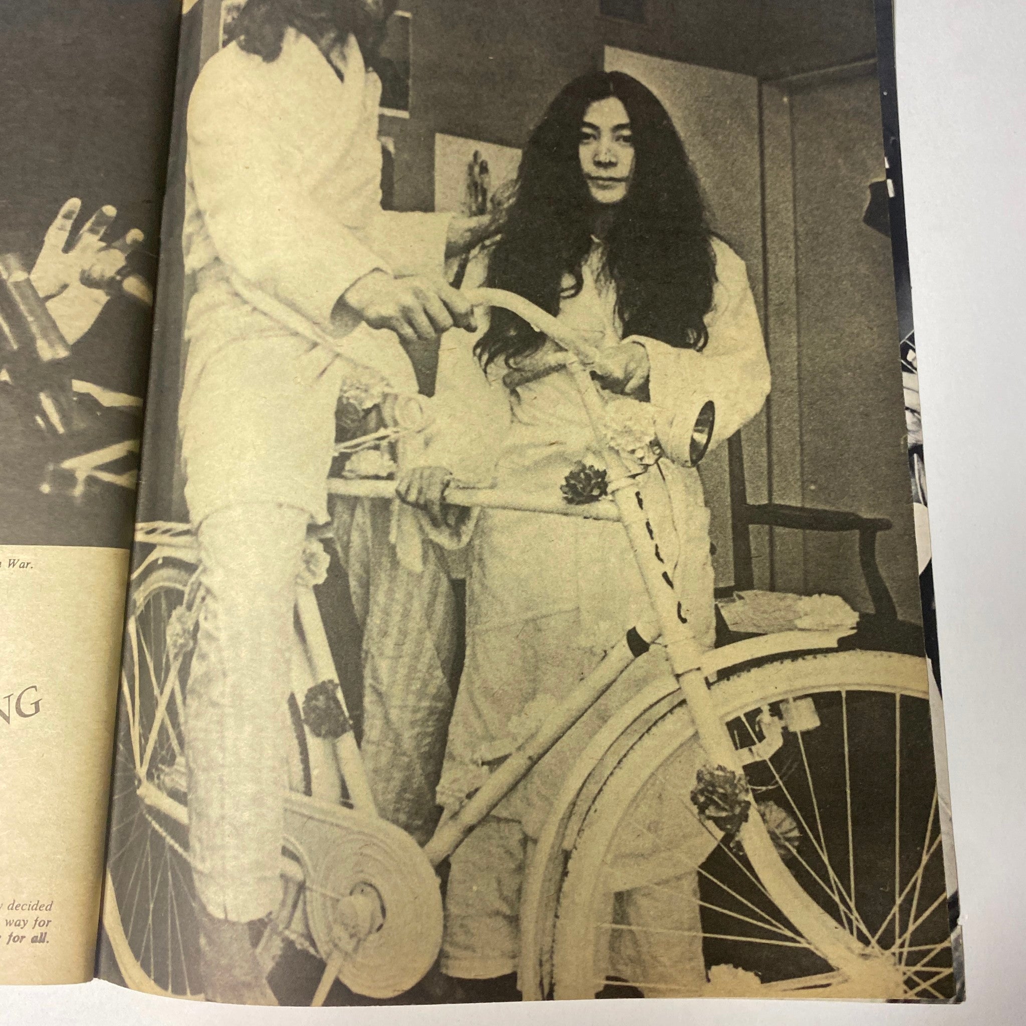 A nostalgic moment featuring John Lennon and Yoko Ono in their iconic photoshoot for the 'Beatles Special John Lennon and Yoko Ono: Their Love Book Collector's Edition.' Yoko Ono sits on a white bicycle, capturing their unique love and artistic collaboration. This image celebrates their relationship and connection during the 1960s.