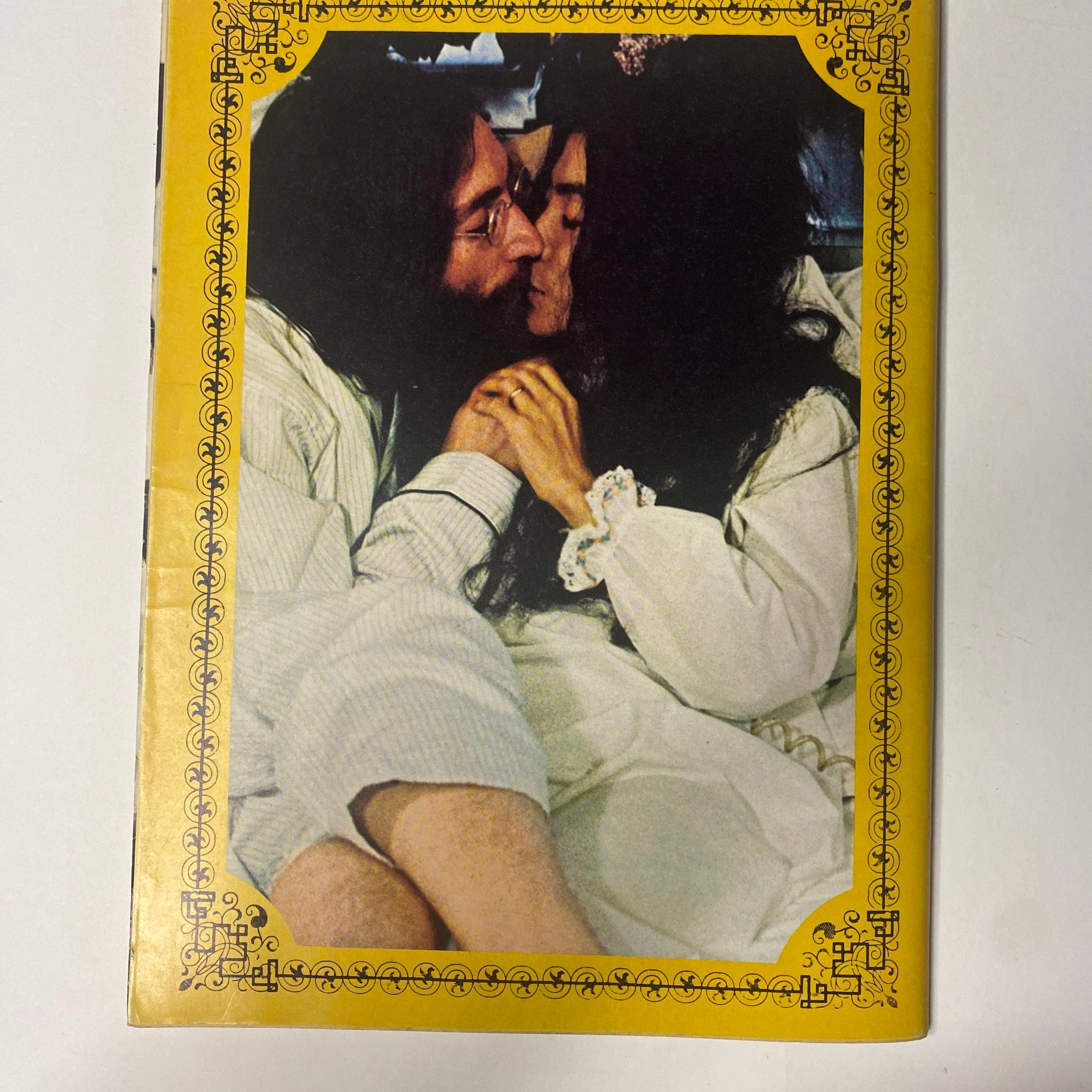 John Lennon and Yoko Ono share a tender kiss in this intimate photo from the 'Beatles Special John Lennon and Yoko Ono: Their Love Book Collector's Edition.' The image highlights their deep affection for one another, reflecting their influential partnership and creative journey.