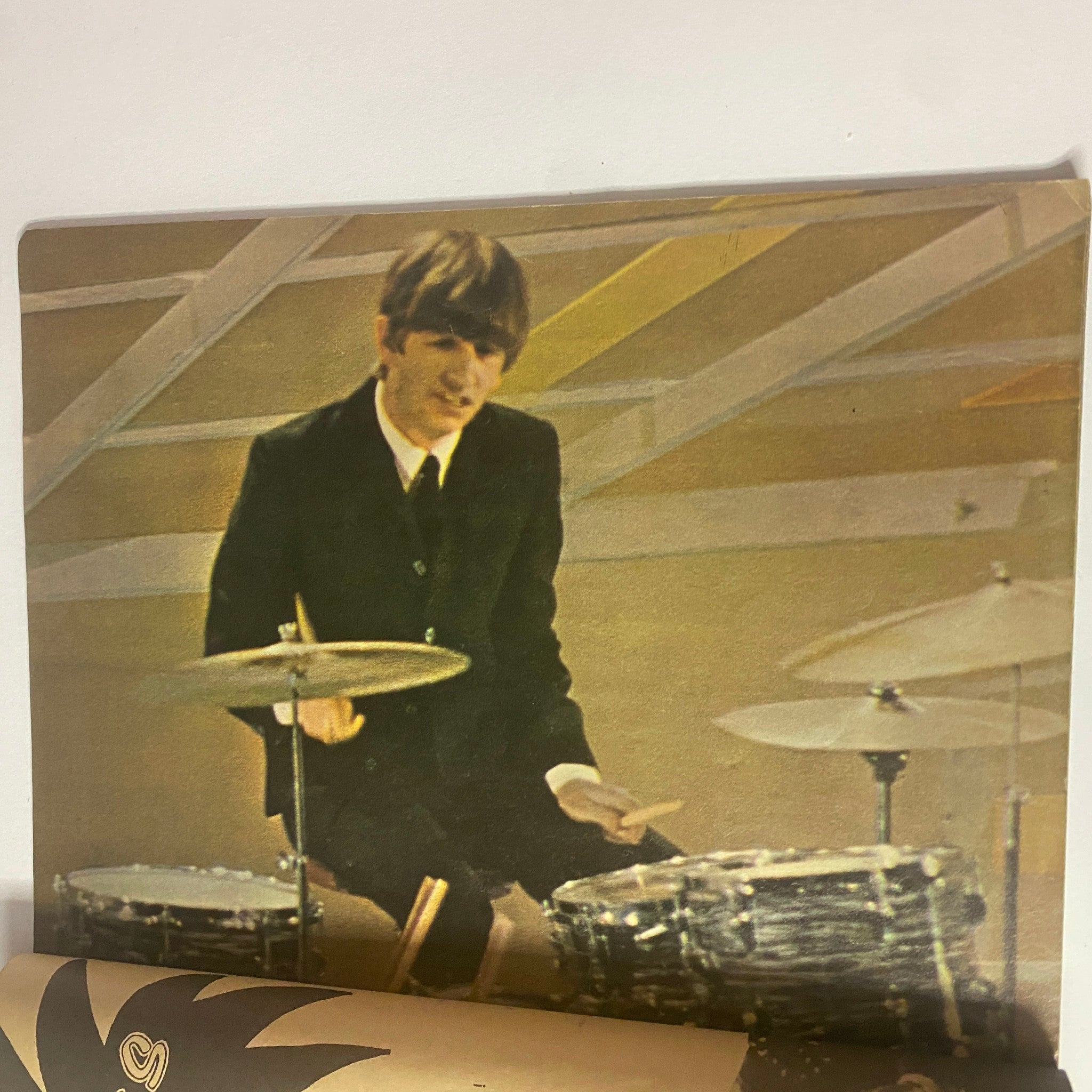 A young Ringo Starr playing the drums in Teen Screen Magazine 1964 The Beatles Color Pinup Album, capturing the essence of Beatlemania with vibrant colors.