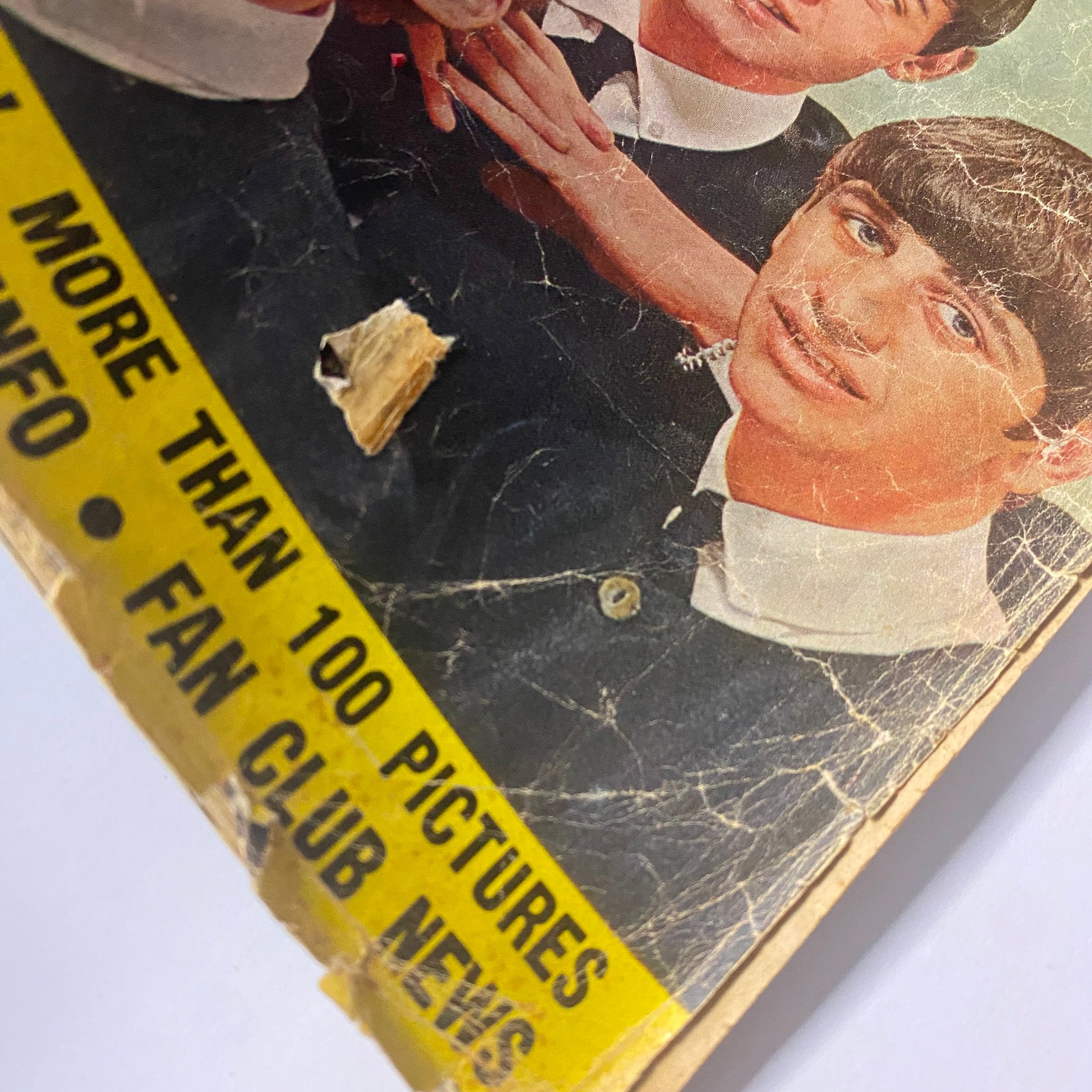 Close-up of the cover of 1964 All About The Beatles No. 1 magazine, displaying John Lennon and Ringo Starr with some damage.