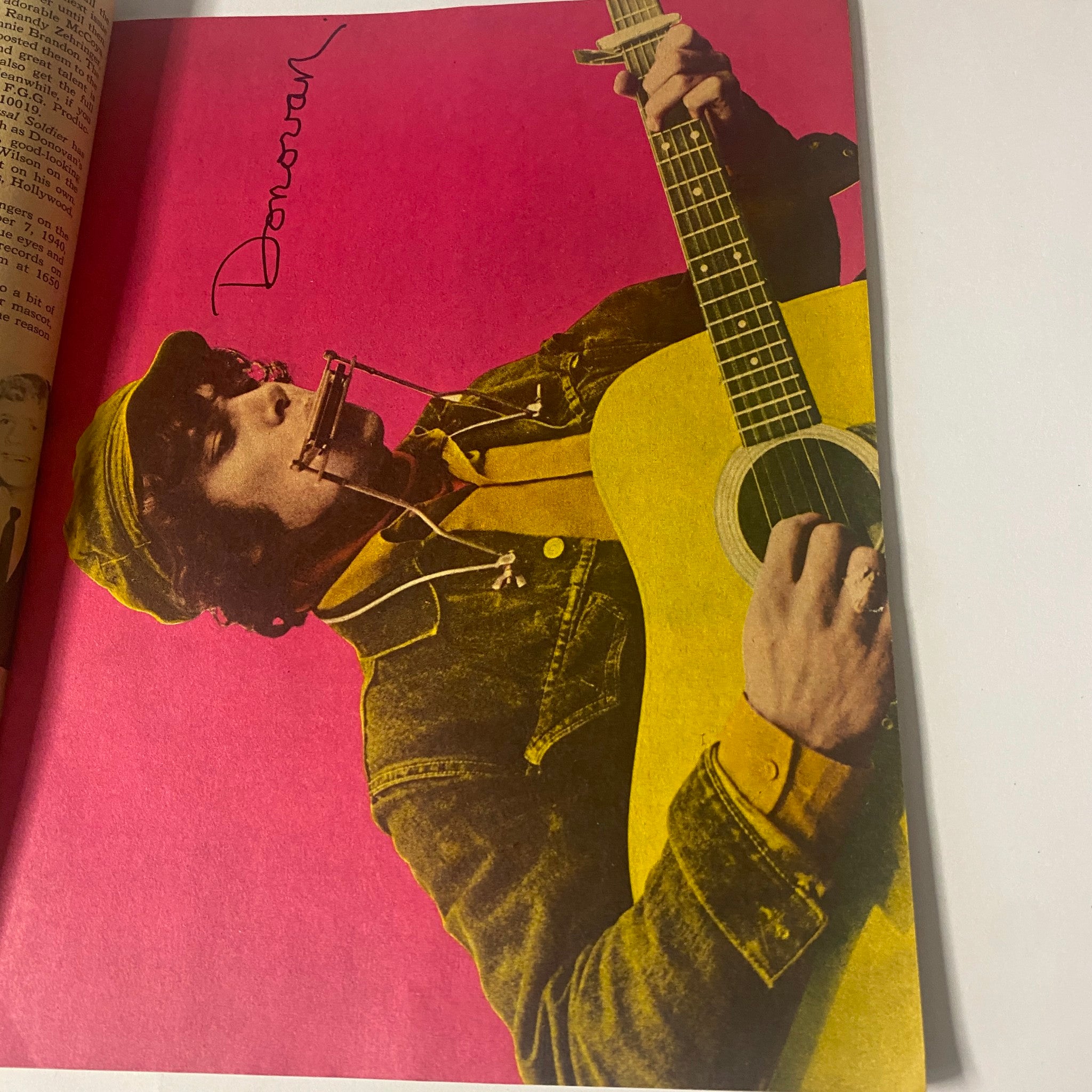 Vibrant image of Donovan playing guitar, featured in 16 Magazine January 1966 Vol 7 No. 8.