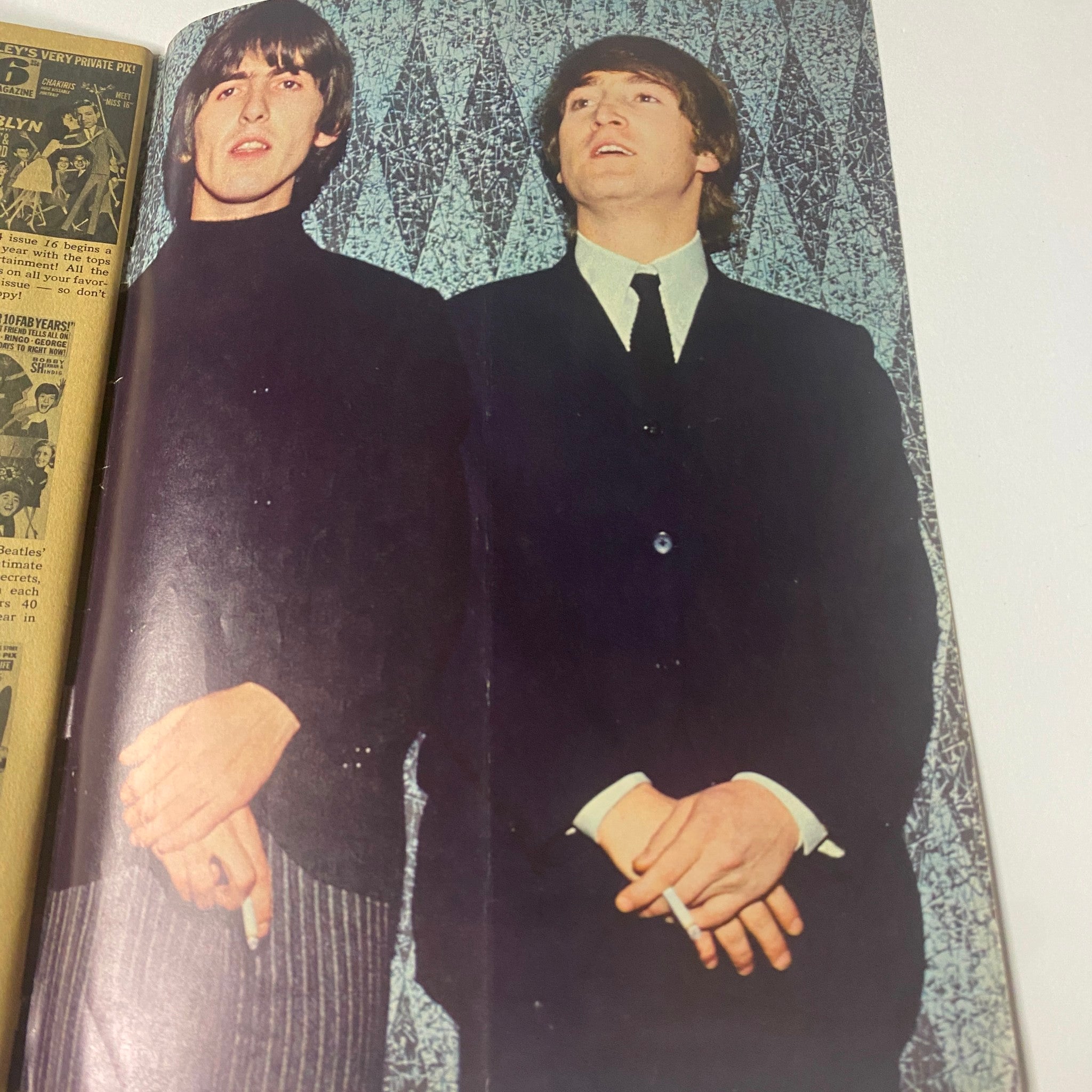 Photograph of John Lennon and George Harrison from 16 Magazine October 1965, depicting the duo in stylish attire, relevant to the era of the British Invasion.