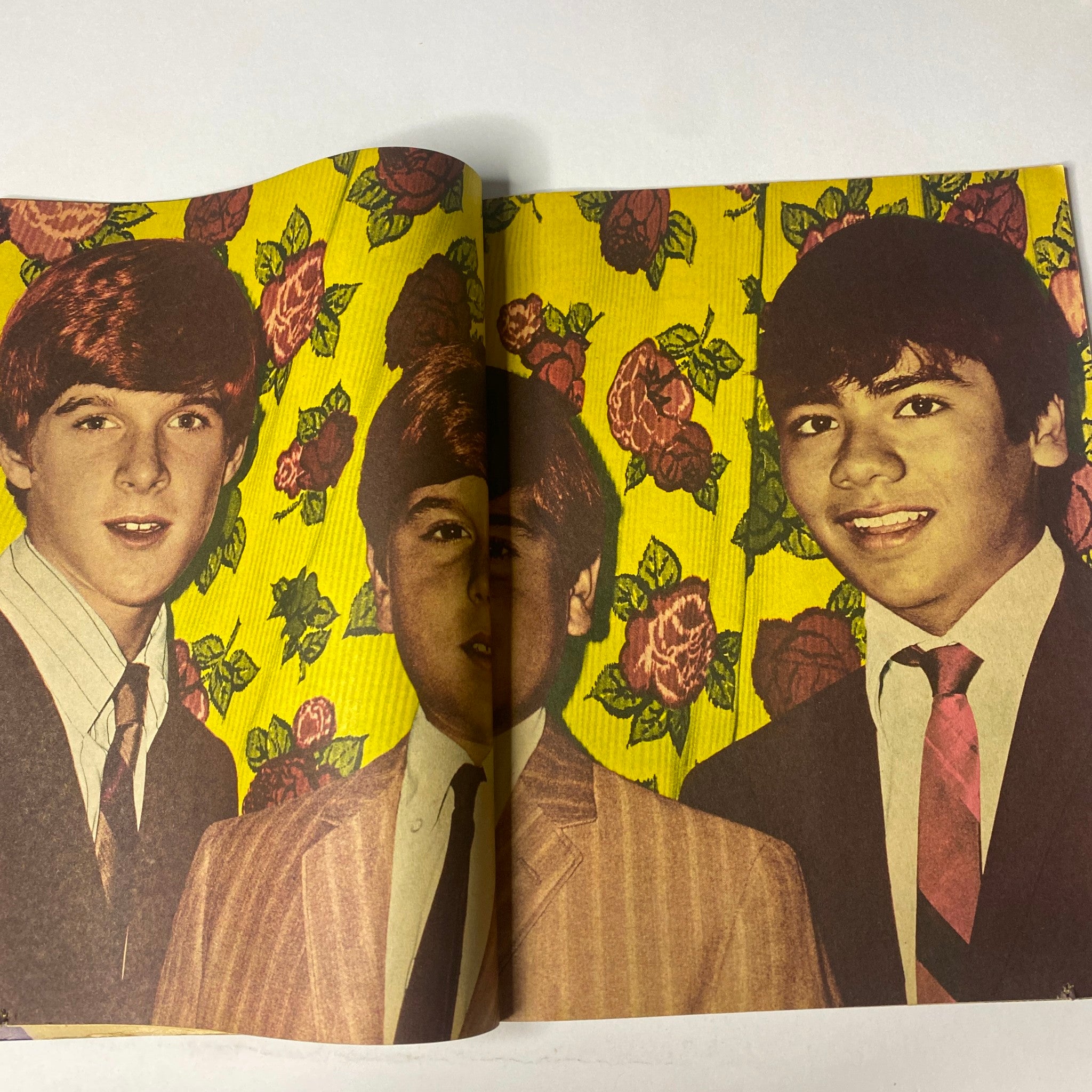 Image from 16 Magazine December 1965 Vol 7 No 7 showcasing three young men in front of a floral background, representative of 1960s youth culture.
