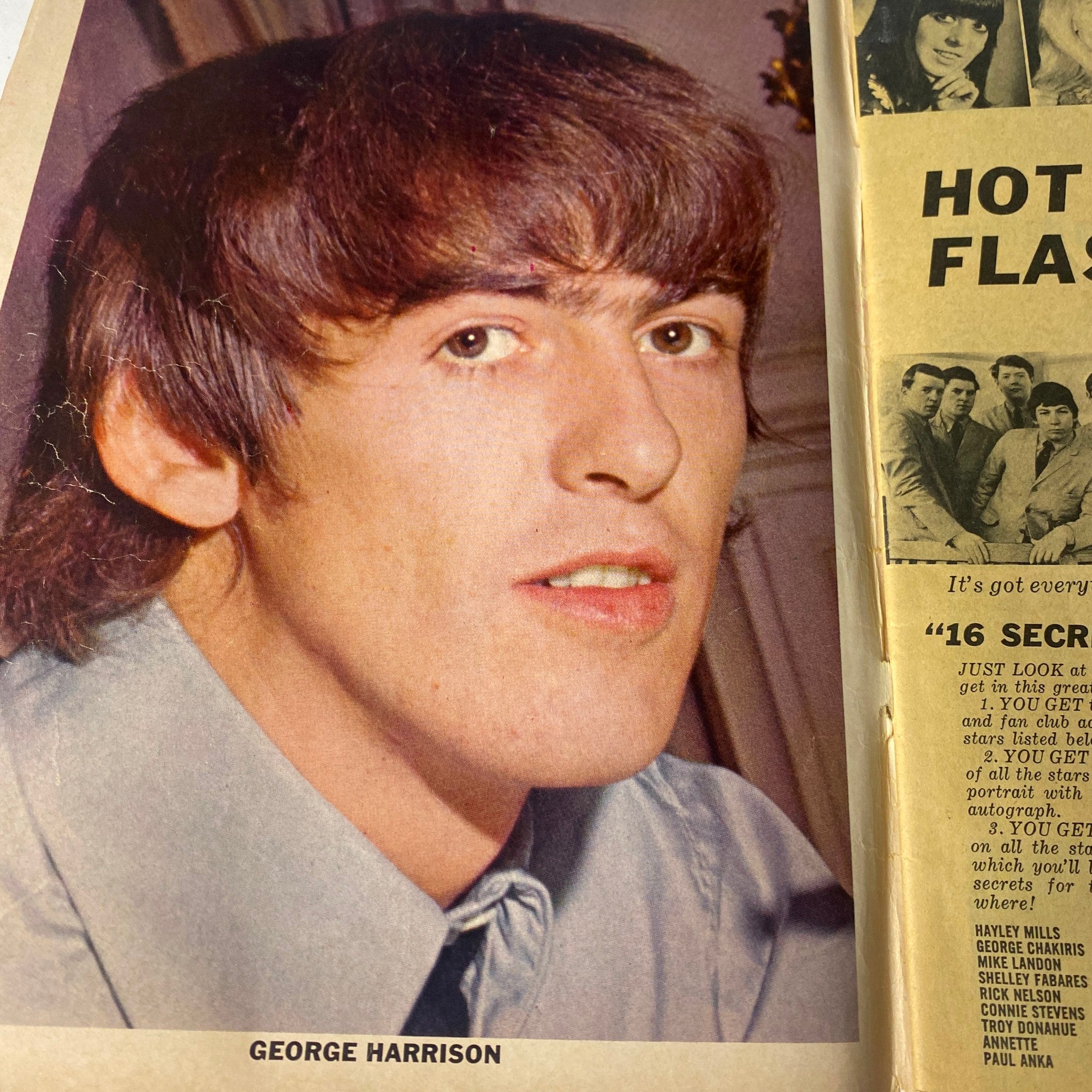 Portrait of George Harrison from 16 Magazine March 1965 with a relaxed expression, wearing a light blue shirt.