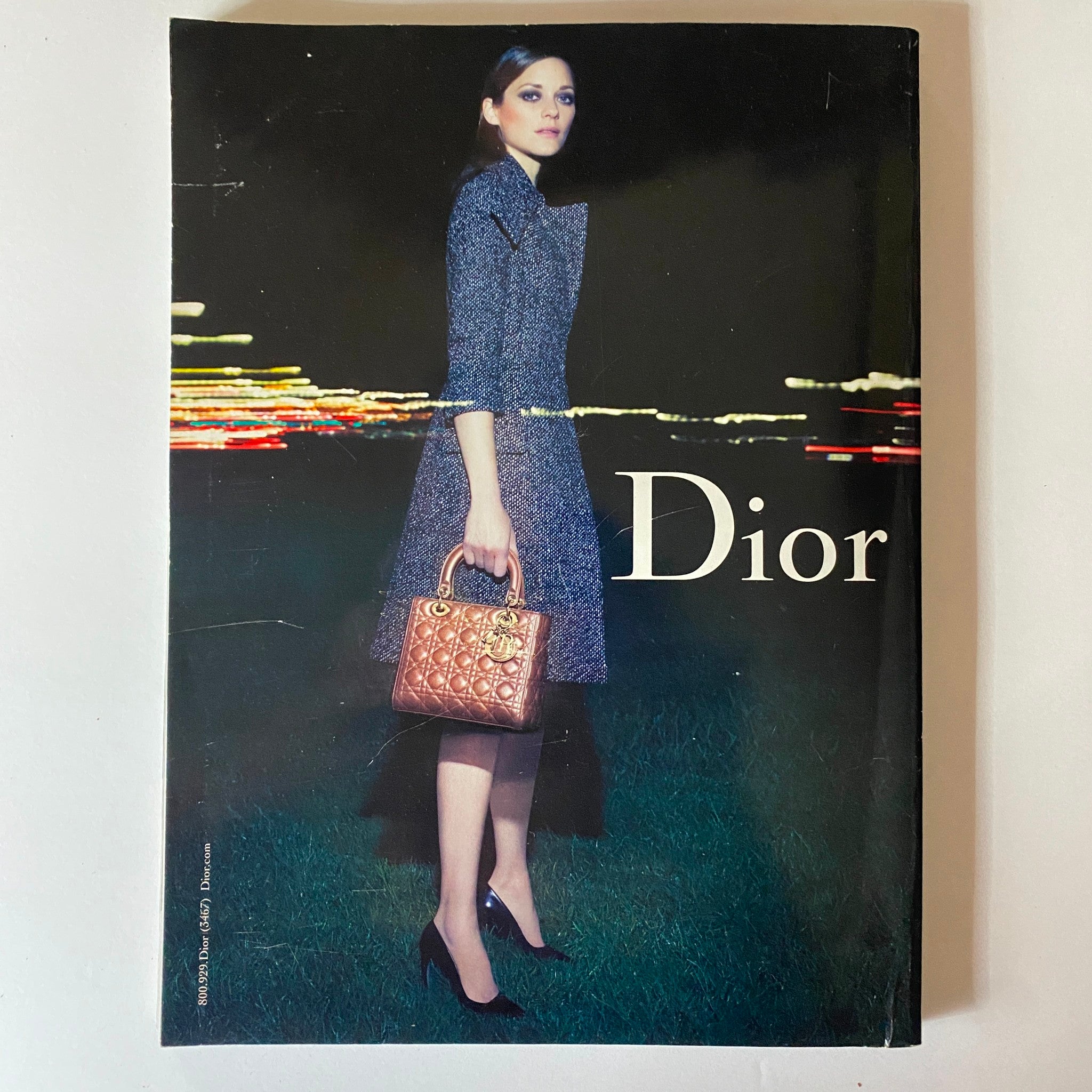 Cover of a Dior magazine showcasing a model in a chic outfit and handbag, emphasizing contemporary fashion trends and aesthetics.