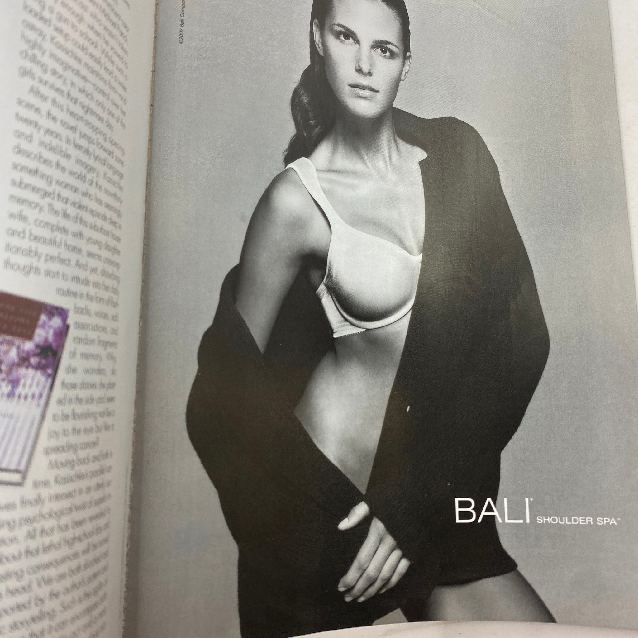 Advertisement from Elle Magazine March 2002 showcasing a model in a bra and oversized cardigan, emphasizing beauty and fashion in a black and white photo.