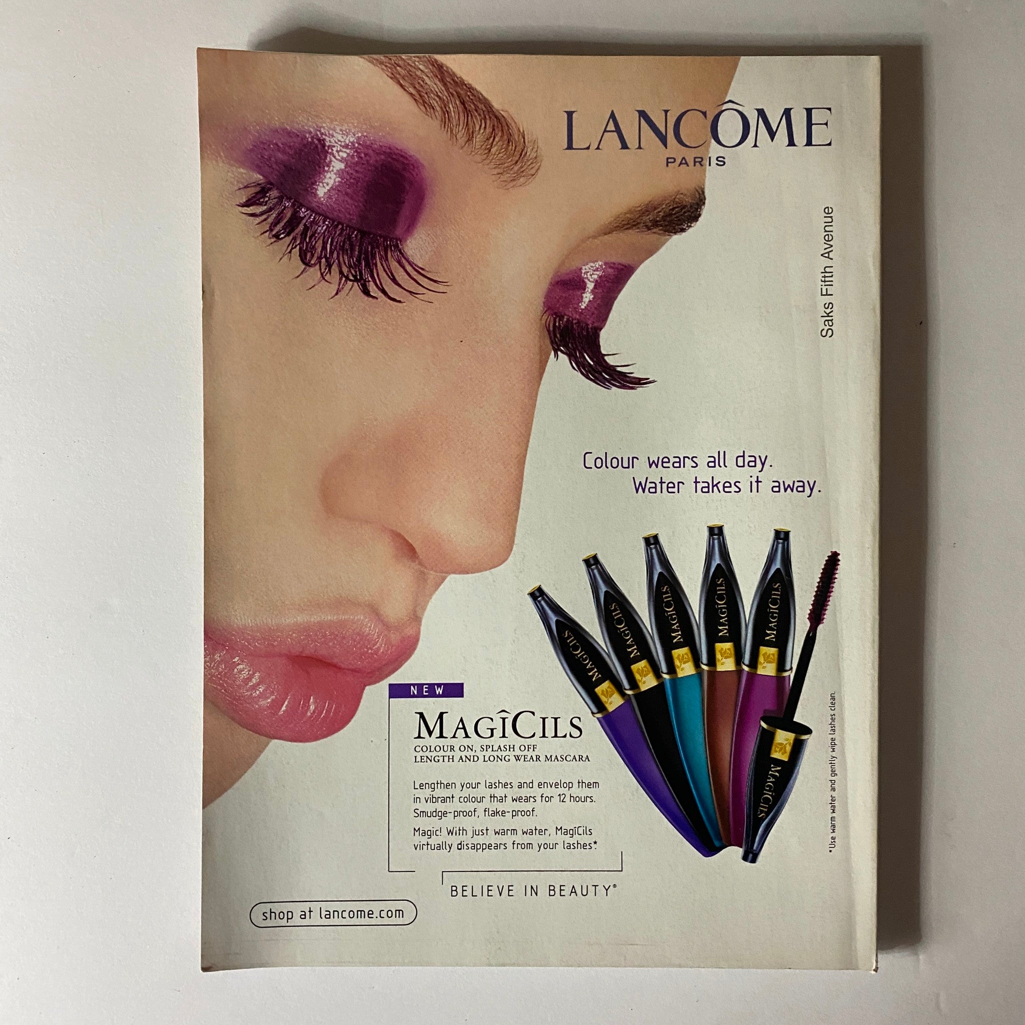 Advertisement for Lancôme MagiCils from Elle Magazine July 2003, showcasing new mascara products with vibrant colors and beauty insights.