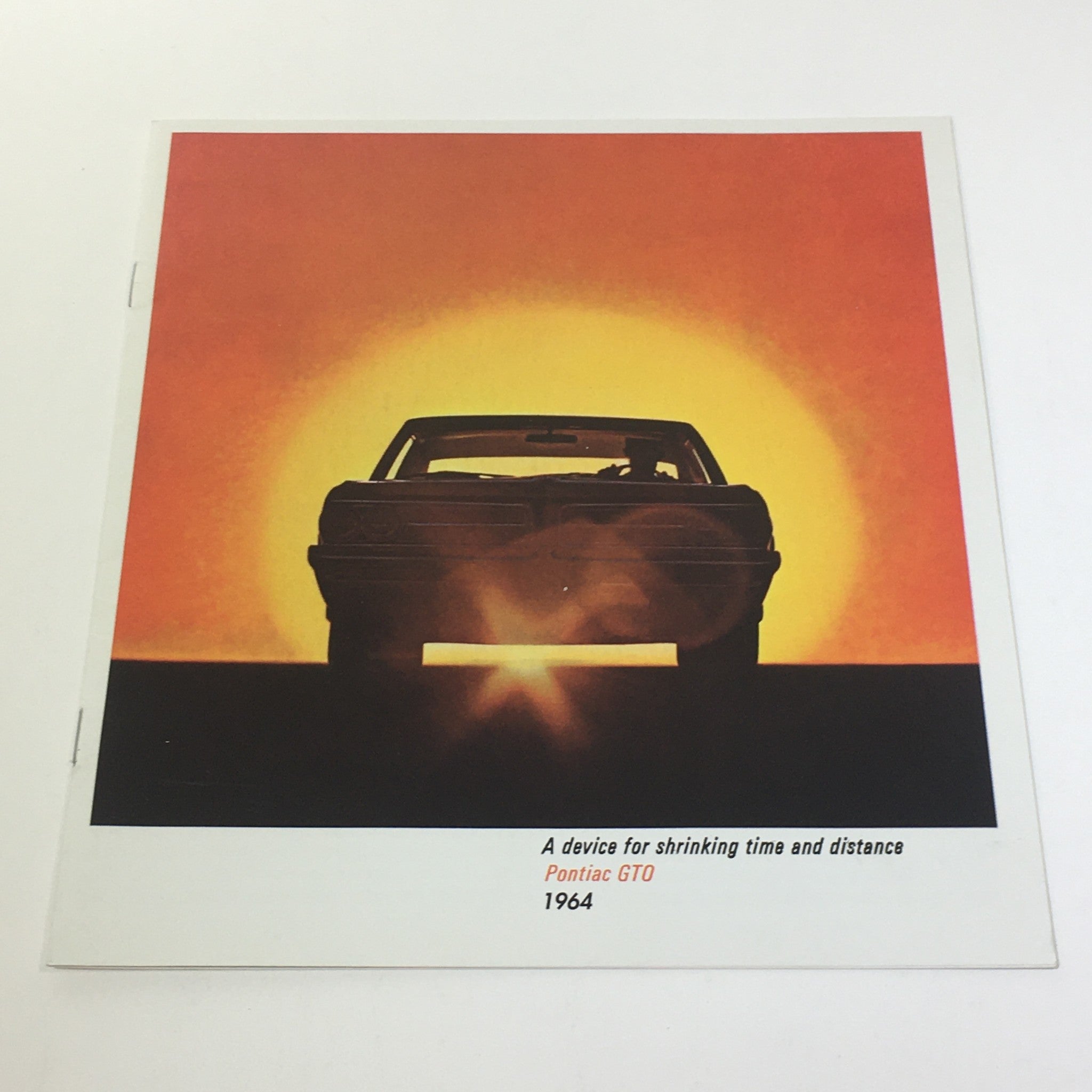 Cover of the 1964 Pontiac GTO catalog featuring a silhouette of the car against a sunset backdrop, emphasizing its iconic design.