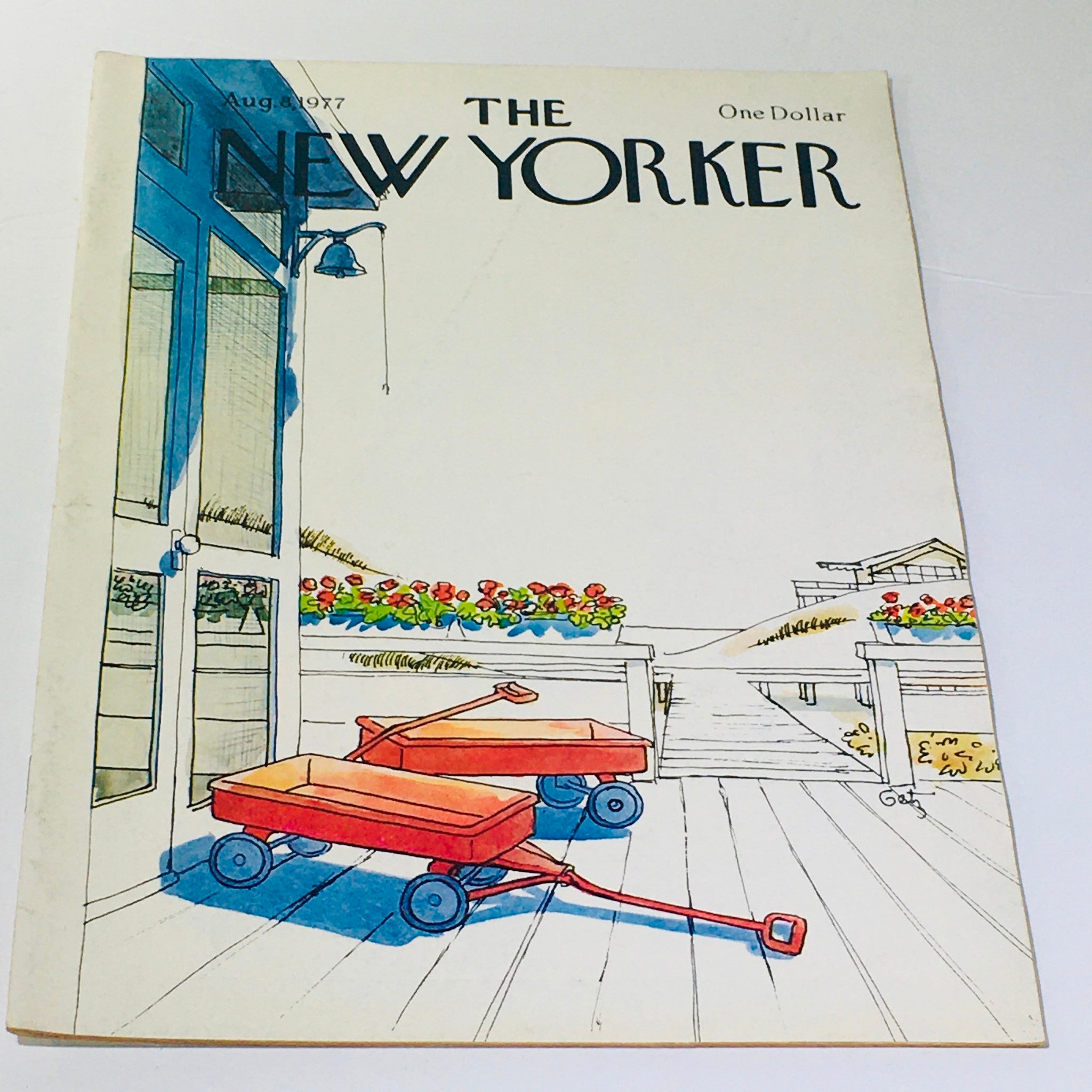 Cover of The New Yorker: August 8, 1977, featuring a vintage illustration of red wagons on a deck surrounded by flowers and a serene backdrop, by artist Arthur Getz.
