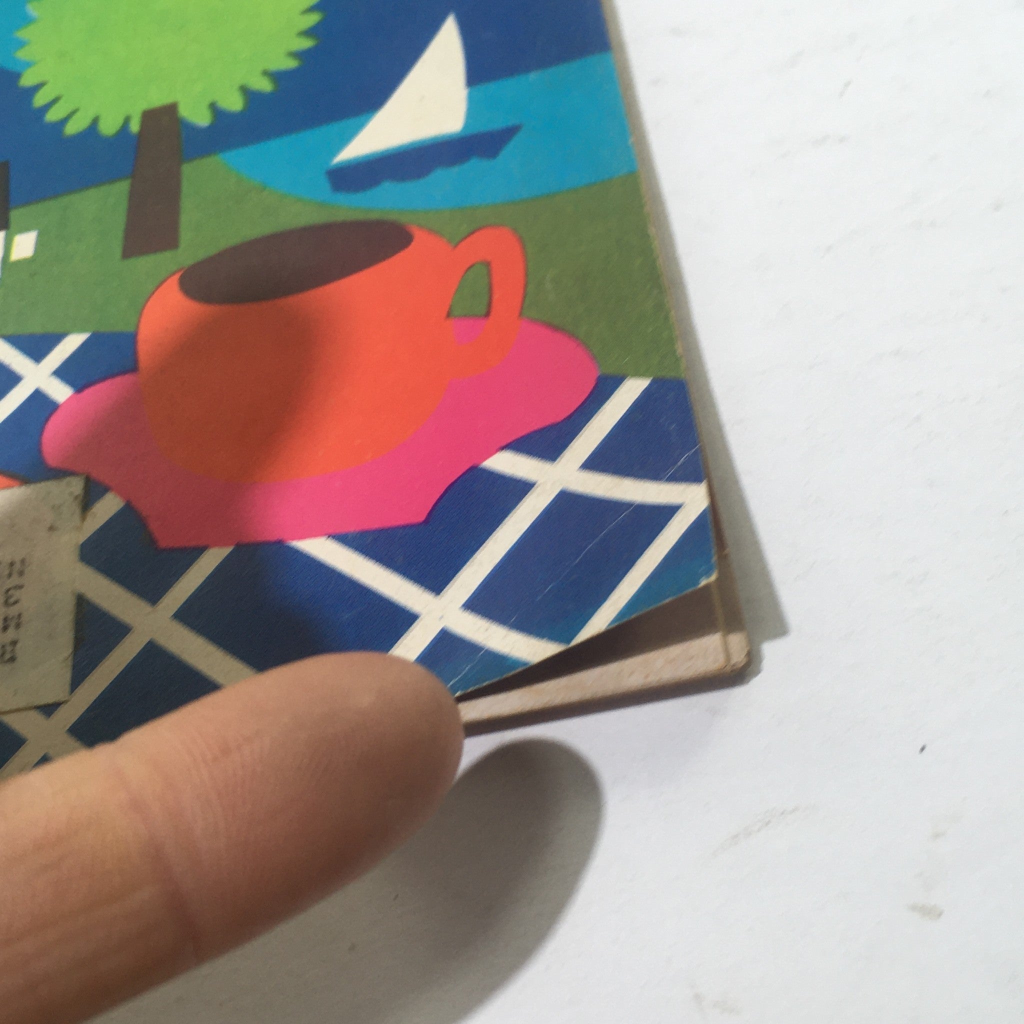 Detail shot of Cue Magazine: June 19 1971 cover highlighting a bright orange cup on a pink coaster, set against a backdrop of scenic outdoor scenery including trees, water, and a sailboat.