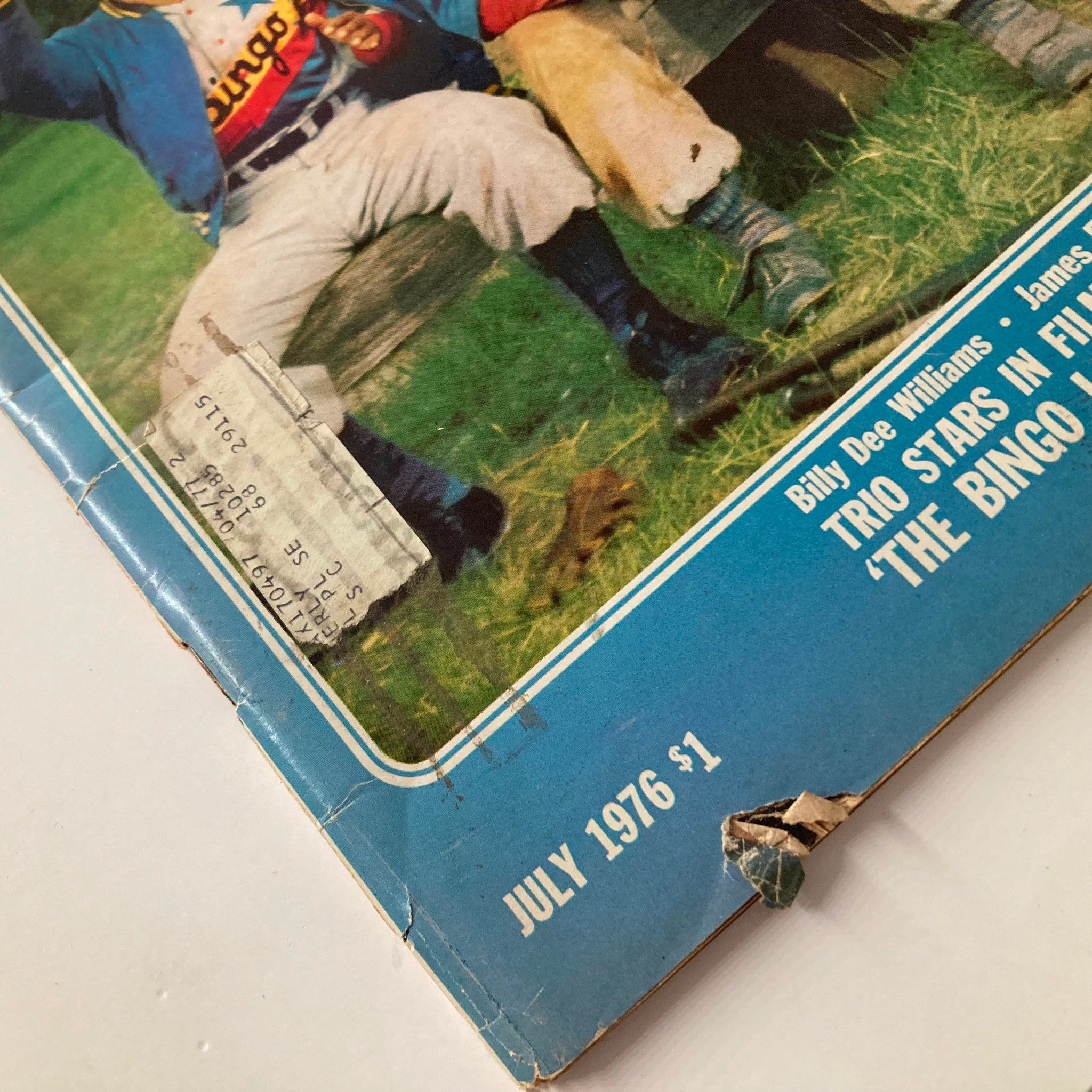 Close-up of the damaged corner of VTG Ebony Magazine July 1976 featuring Billy Dee Williams, James Earl Jones, and Richard Pryor, showcasing the magazine's vintage condition.