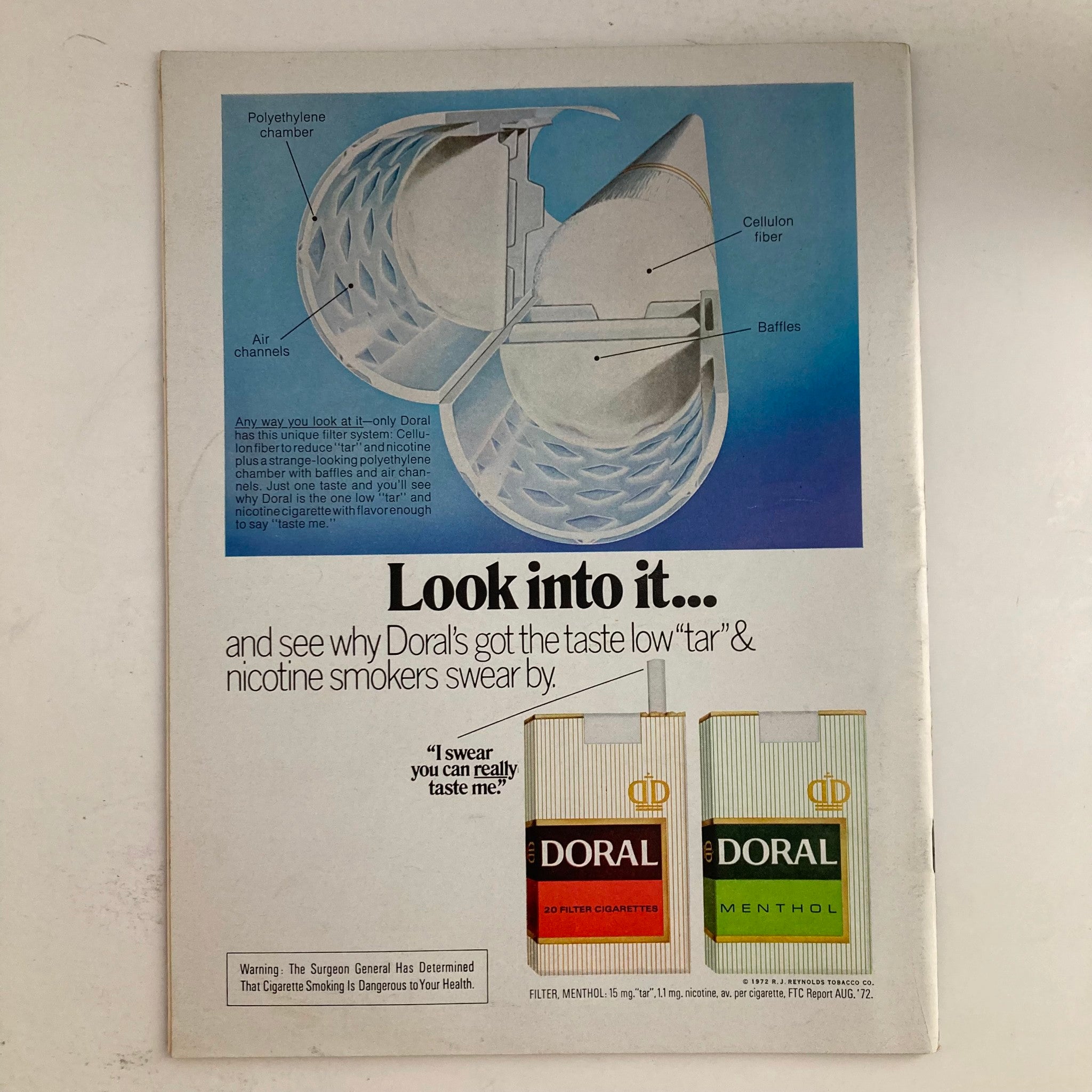 Doral cigarette advertisement from VTG Newsweek Magazine January 8, 1973, showcasing the unique filter system with details about low 'tar' and nicotine. The ad visually highlights the cigarette packaging and a description of the product.
