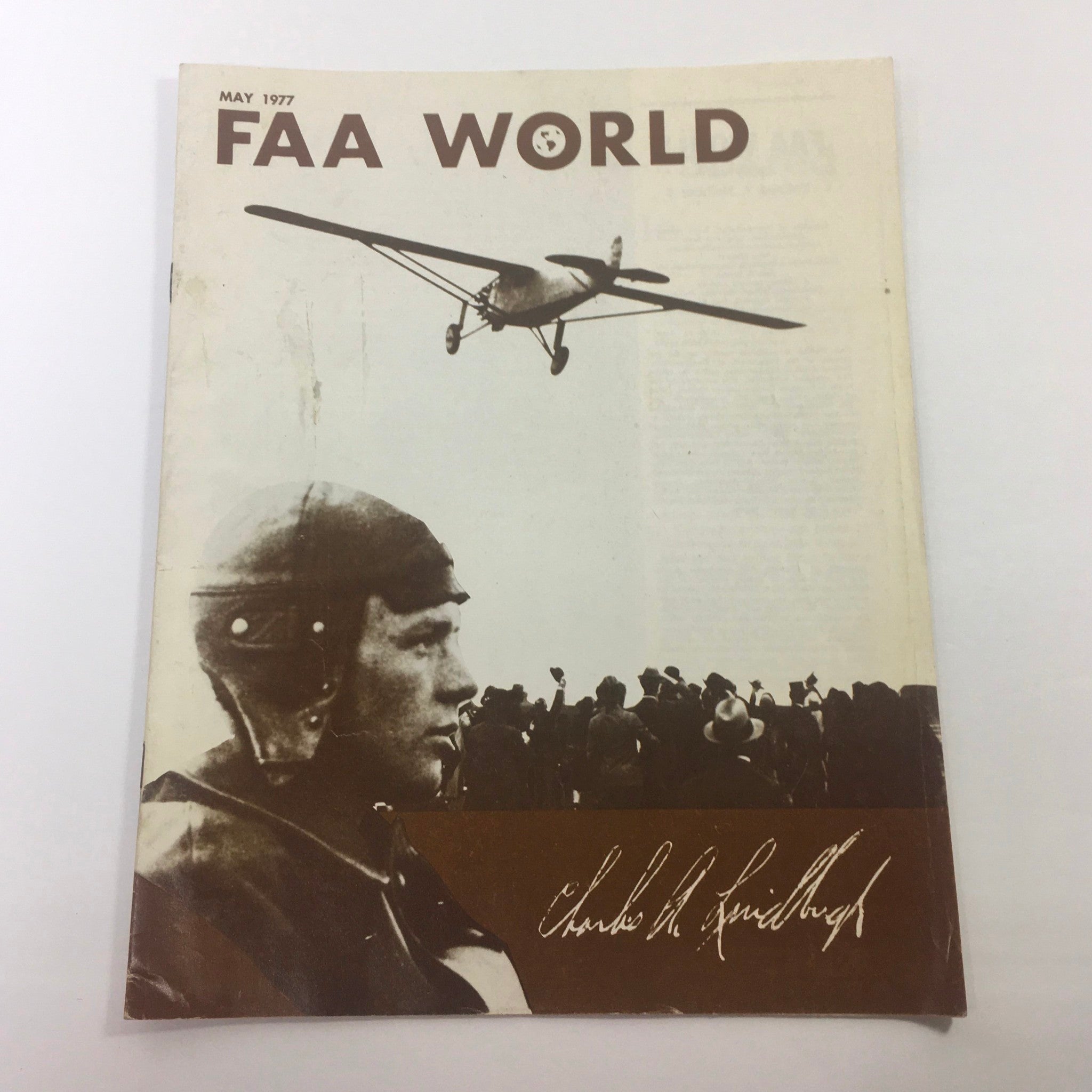Cover of FAA World Magazine: May 1977 featuring an image of Charles A. Luidburgh with an airplane above, showcasing vintage aviation history.