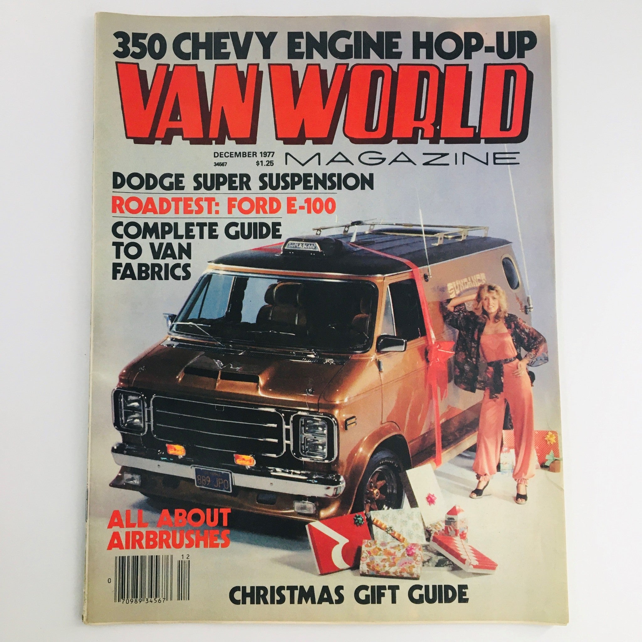 Cover of Van World Magazine December 1977 featuring a 350 Chevy Engine Hop-Up and Ford E-100 Road Test. The cover showcases a vintage van with a female model and holiday gift decorations, highlighting automotive culture of the late 1970s.