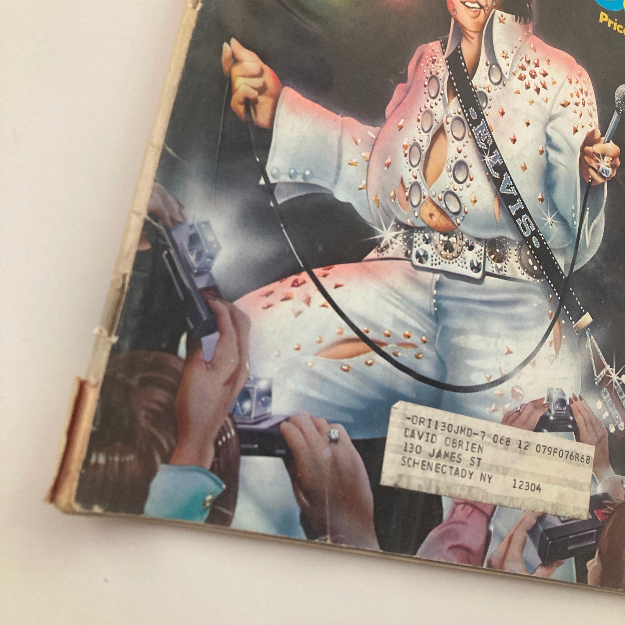 Close-up of the Cover of Vintage National Lampoon Magazine July 1976 showcasing an artistic portrayal of Elvis Presley, highlighting his glamorous outfit and the excitement of the audience.