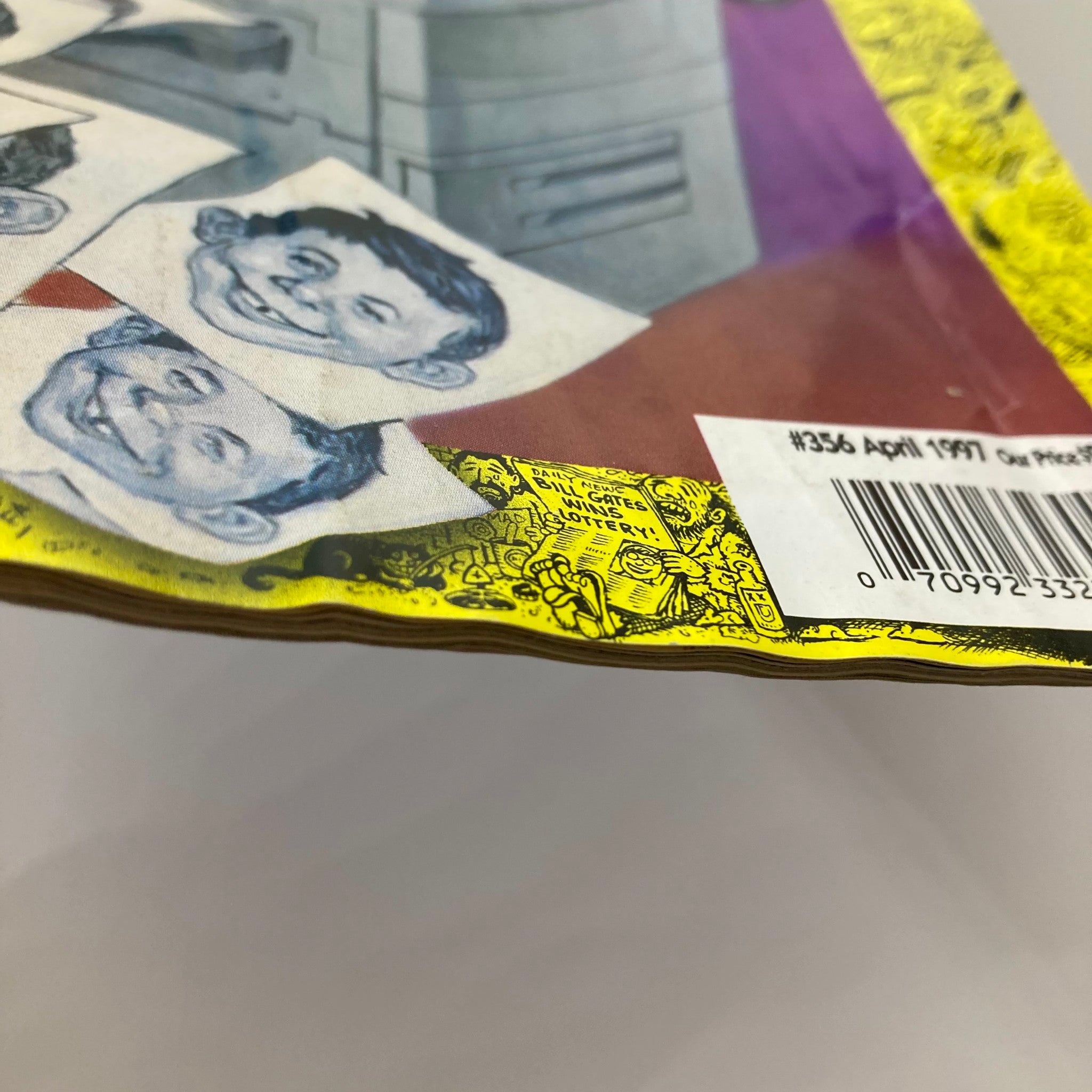 Side view of Mad Magazine April 1997 #356, highlighting the magazine's edge with colorful design and characters, revealing signs of wear and vintage charm.